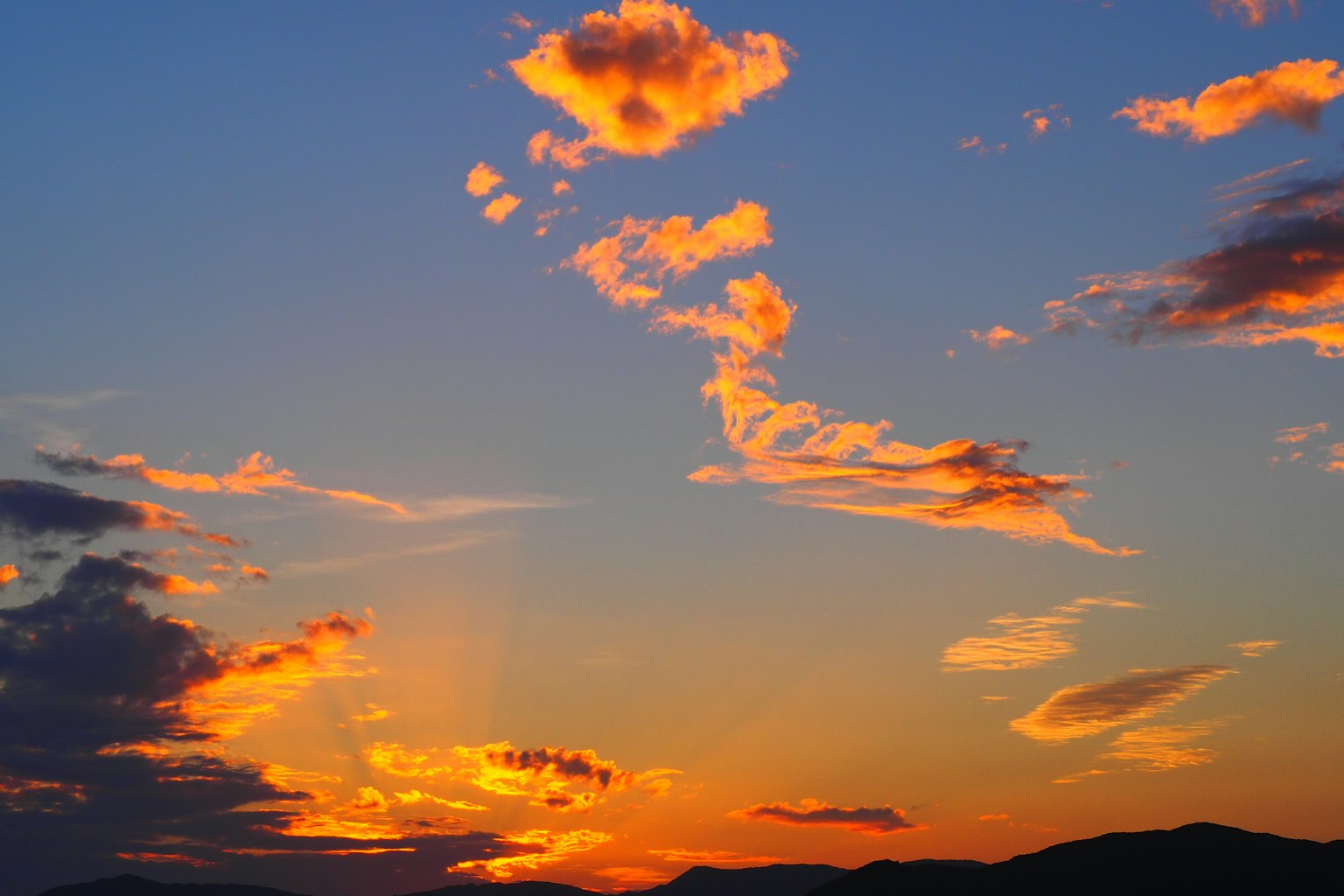 เมฆสีส้มลอยอยู่ในท้องฟ้ายามพระอาทิตย์ตกพร้อมพื้นหลังสีน้ำเงิน