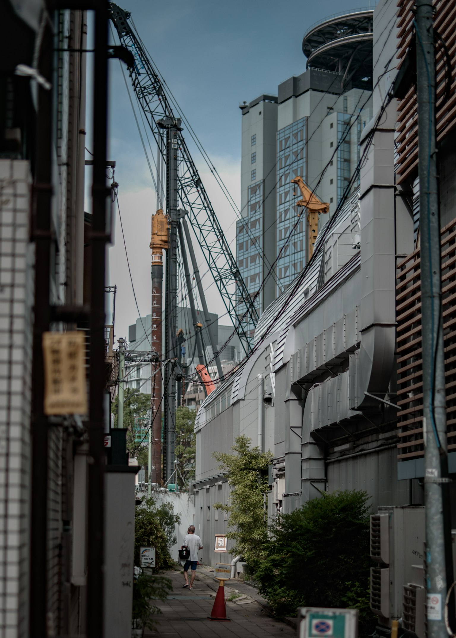 城市风景，狭窄巷道中的起重机和高楼大厦