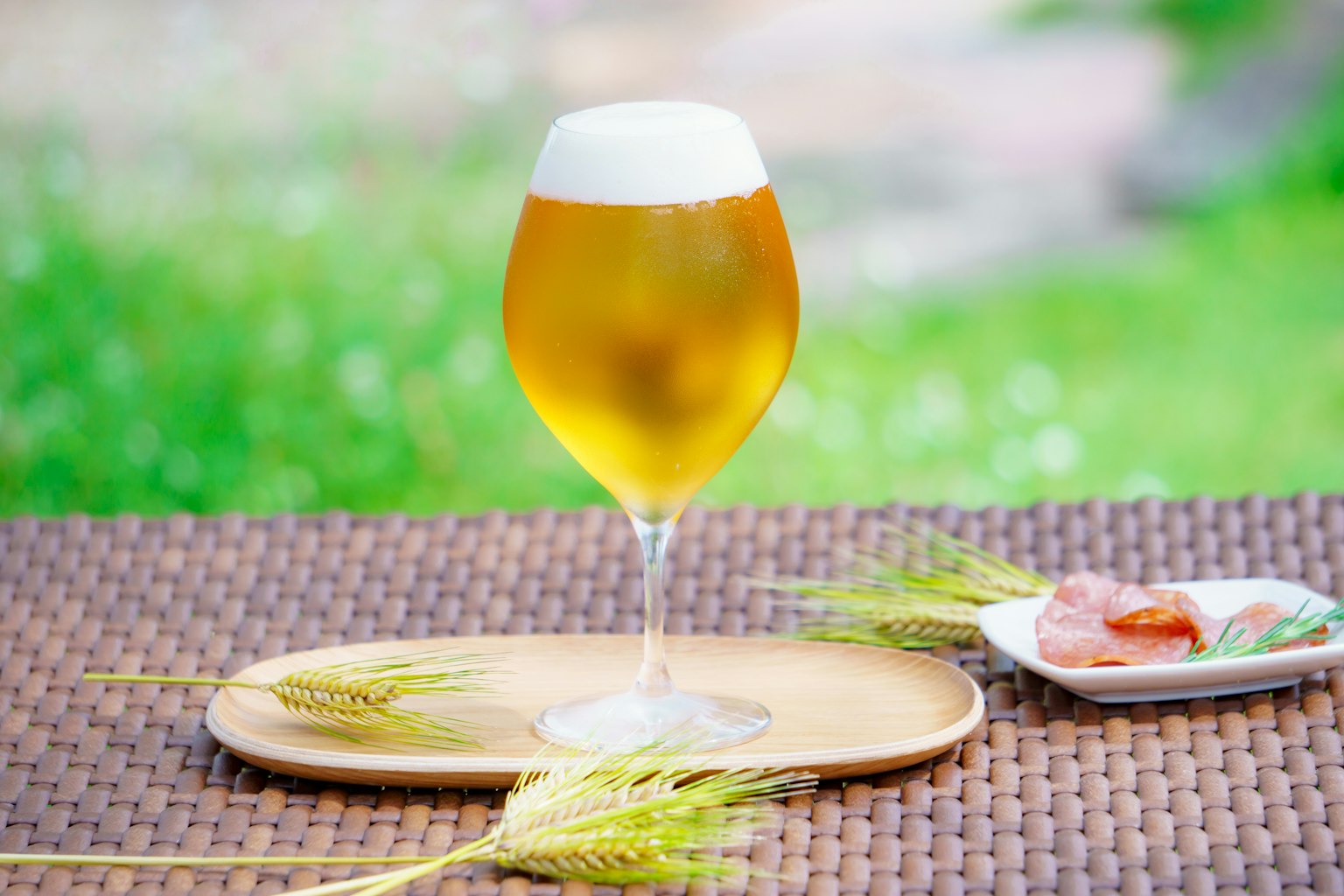Un bicchiere di birra con schiuma su un tavolo con snack