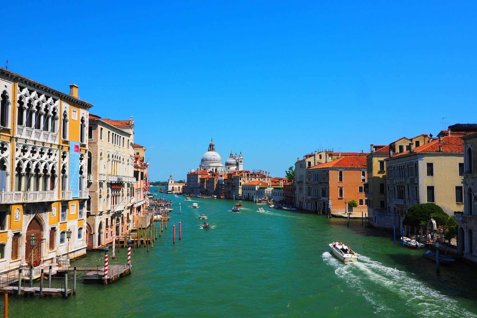 Venezianischer Kanal mit historischen Gebäuden unter blauem Himmel