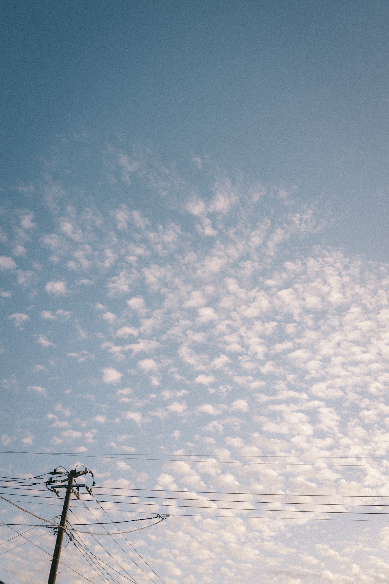 Cielo blu con nuvole bianche e un palo della luce