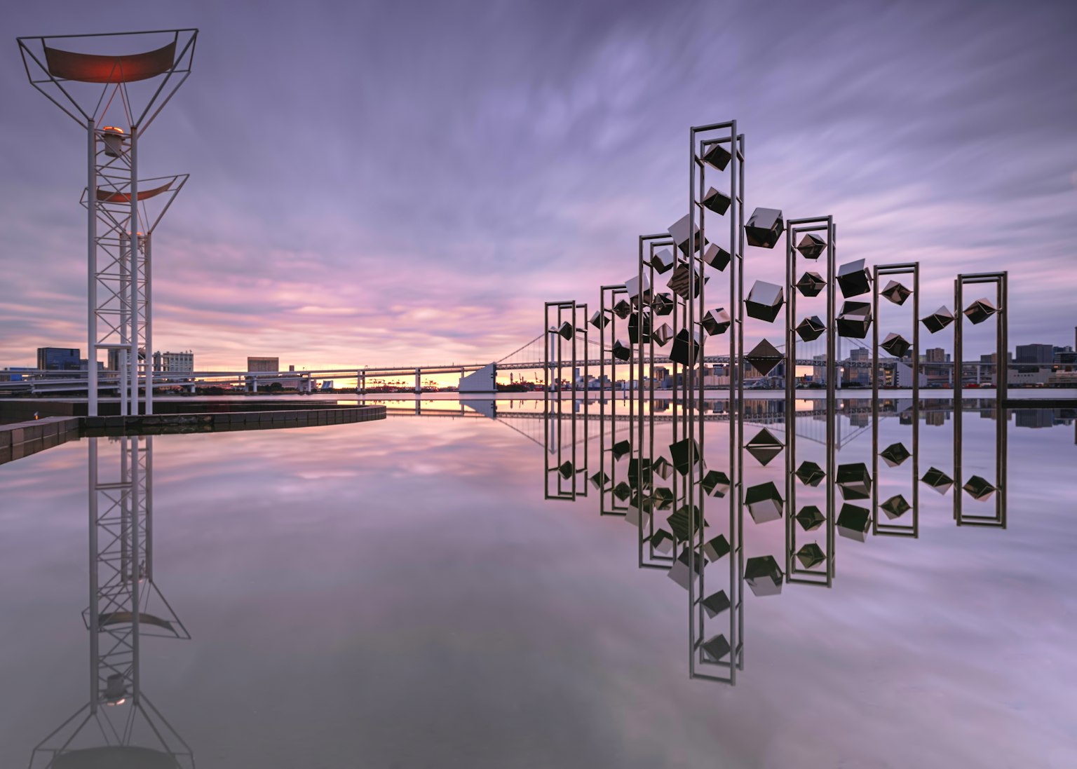 Sculptures modernes et silhouettes de bâtiments reflétées sur l'eau au coucher du soleil avec un ciel magnifique