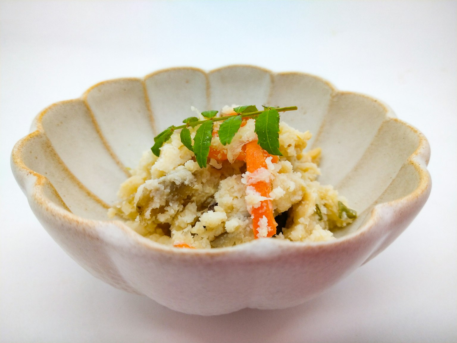 Japanese dish served in a beautiful shell-shaped bowl with colorful vegetables