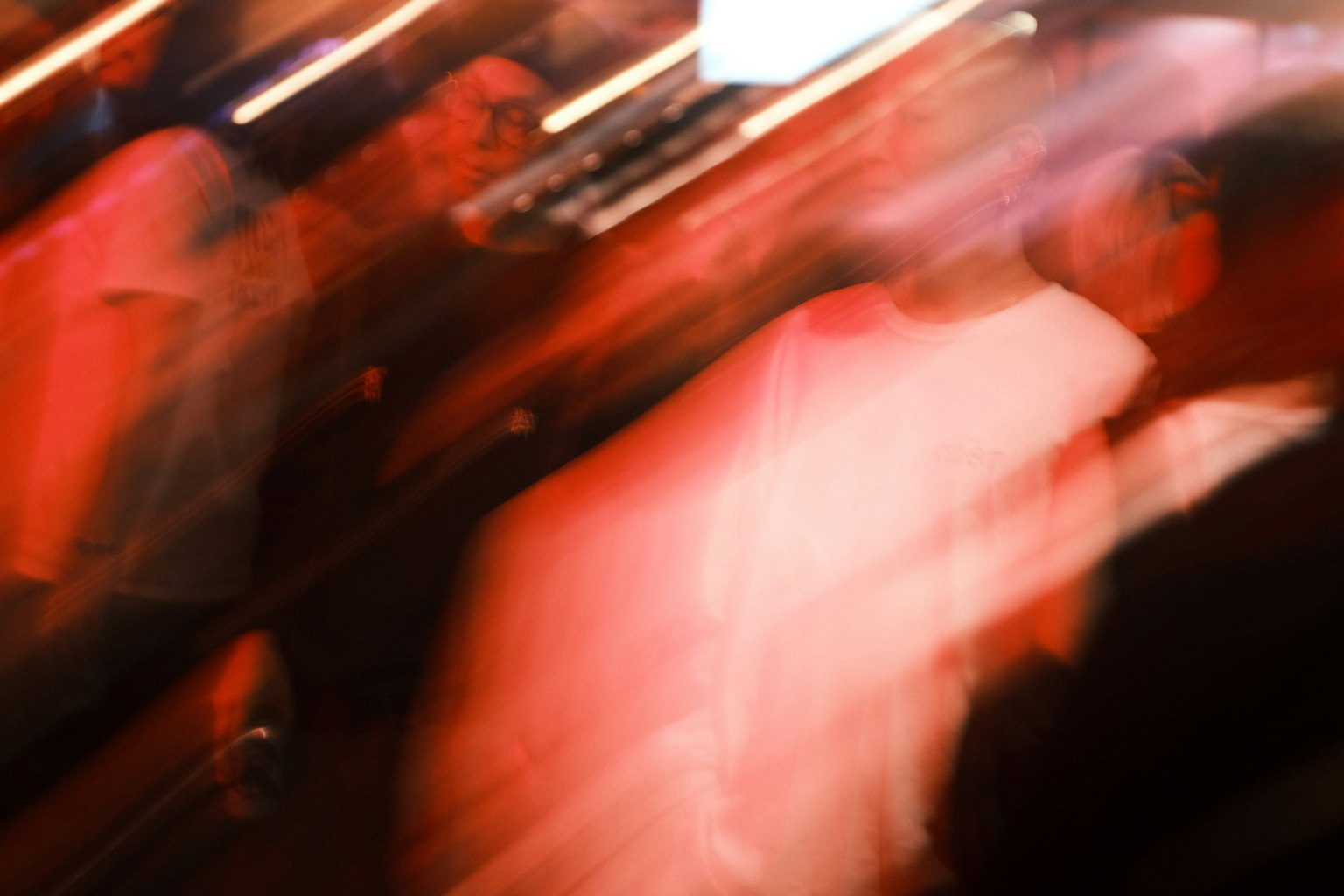 ภาพเบลอของฝูงชนที่มีการเคลื่อนไหวและเอฟเฟกต์แสงสีแดง