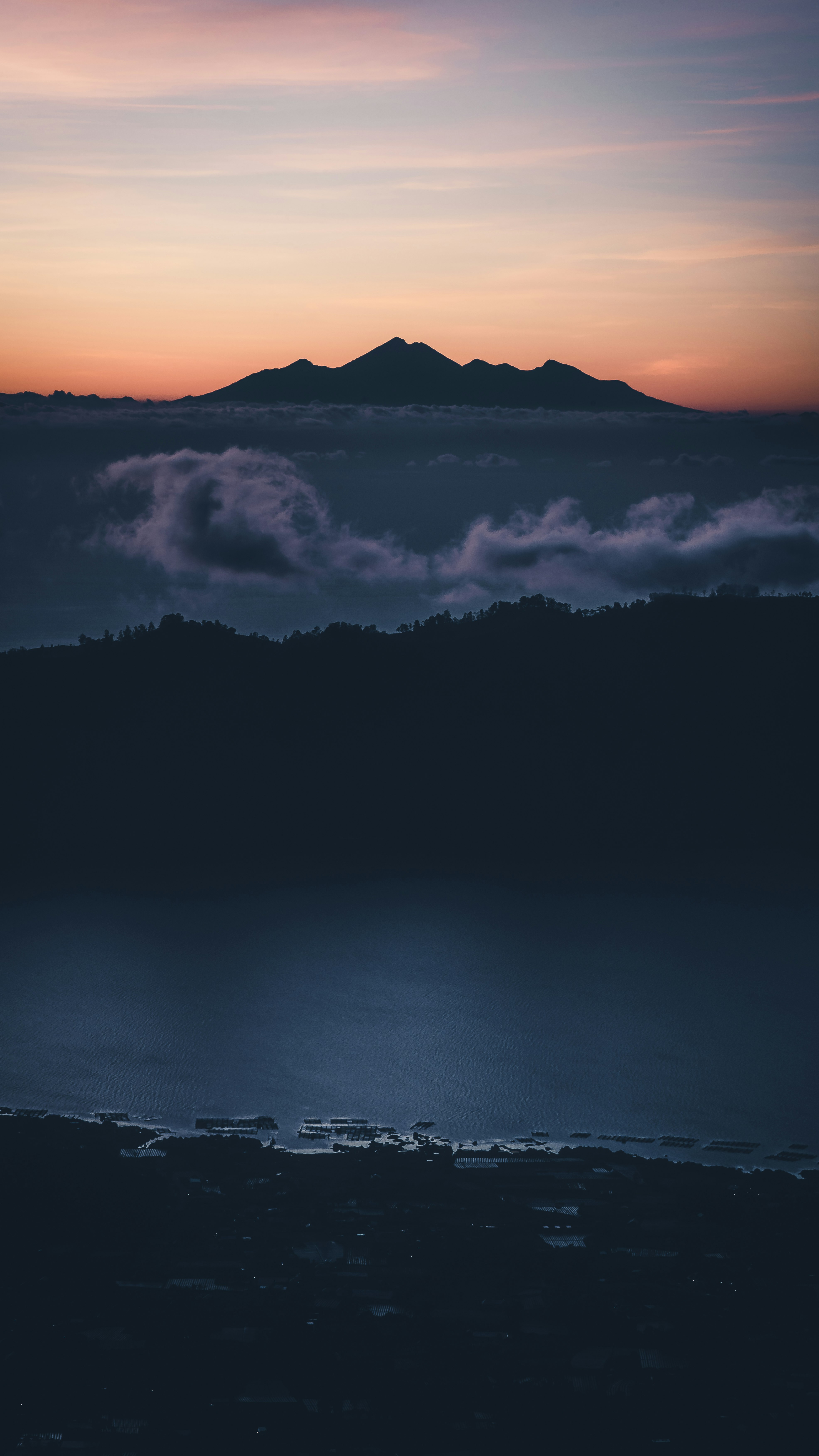 夕焼けの空と霧に包まれた山並みのシルエット