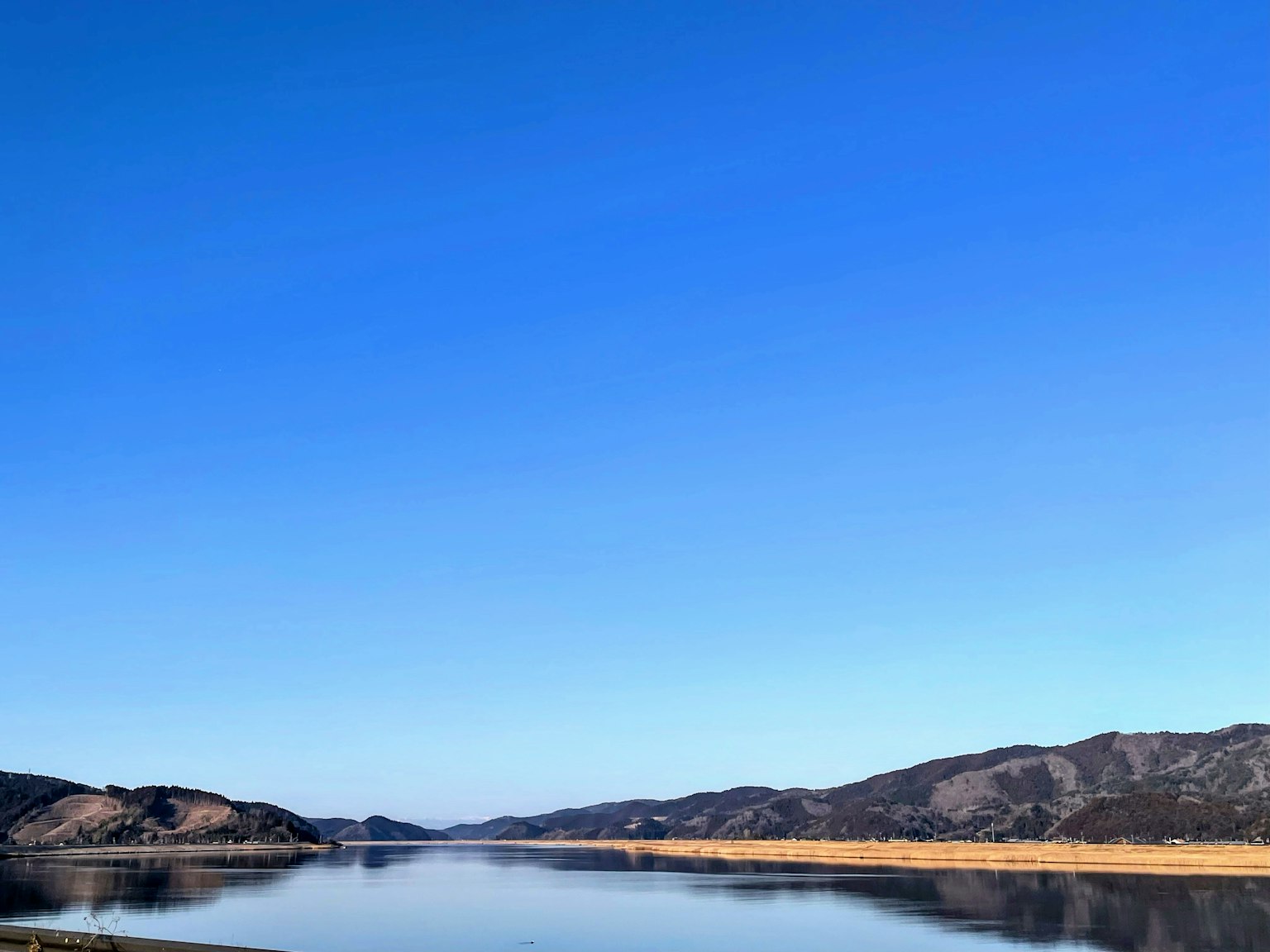 Un paysage serein avec un ciel bleu clair et une rivière calme