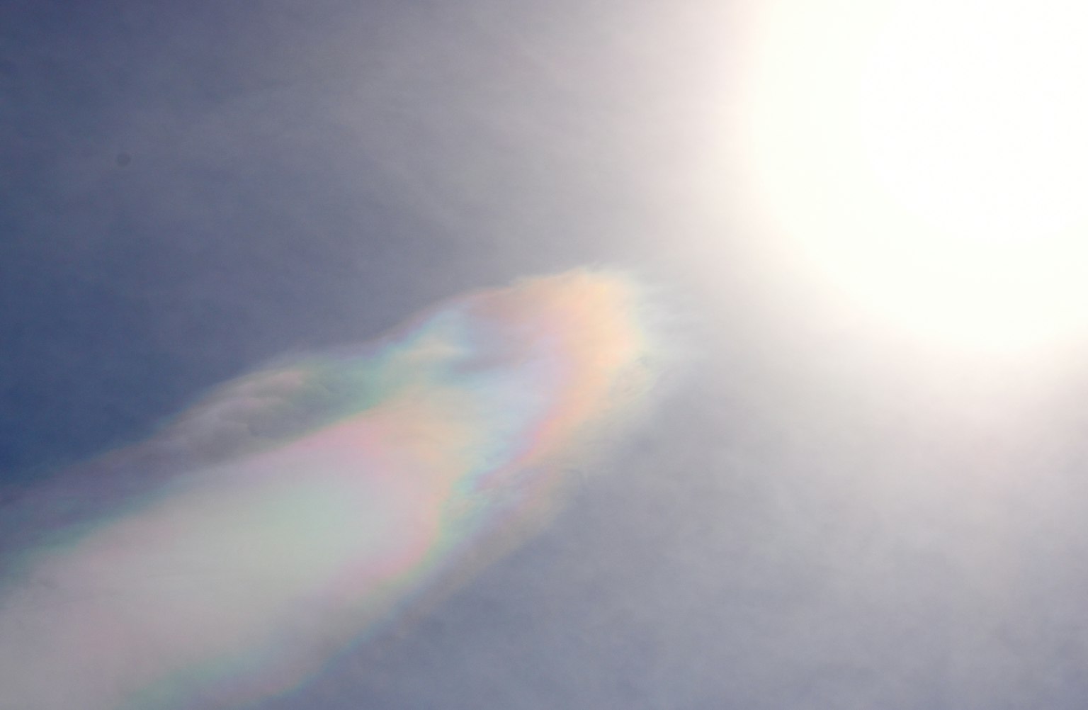 藍天中明亮的太陽和彩虹色的雲