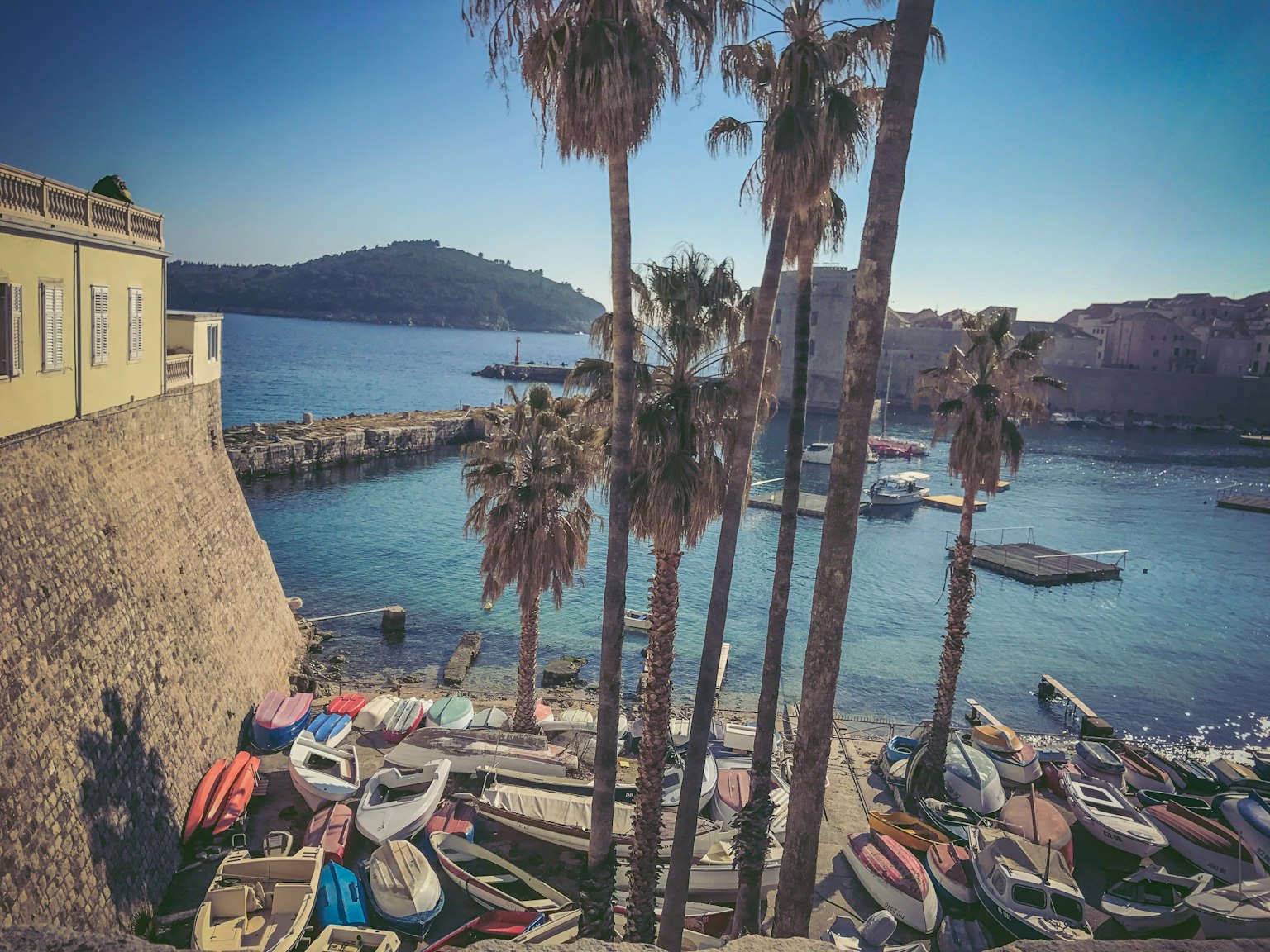 Vista panoramica di acqua blu con barche e palme