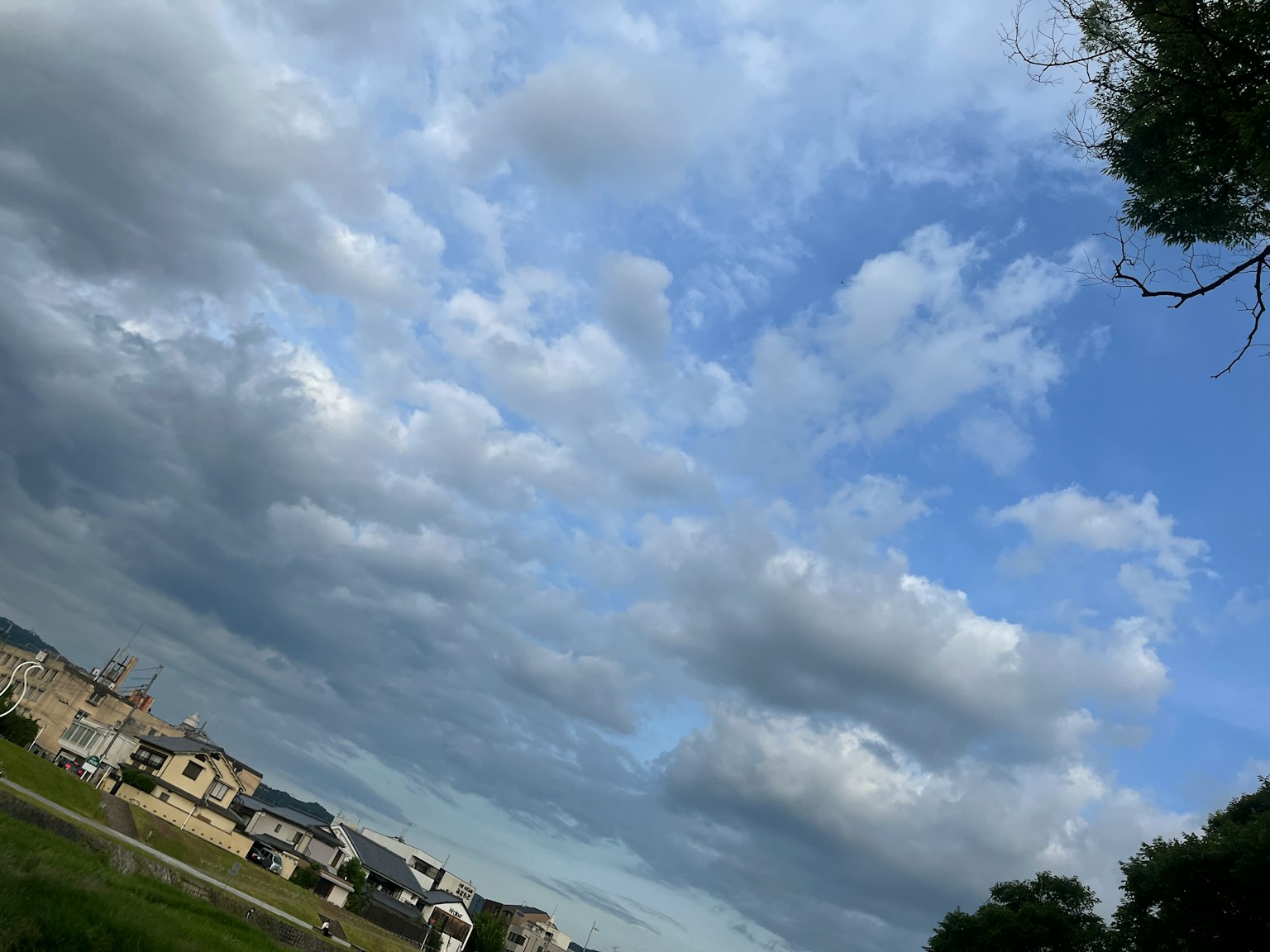 Landschaft mit blauem Himmel und weißen Wolken mit Häusern