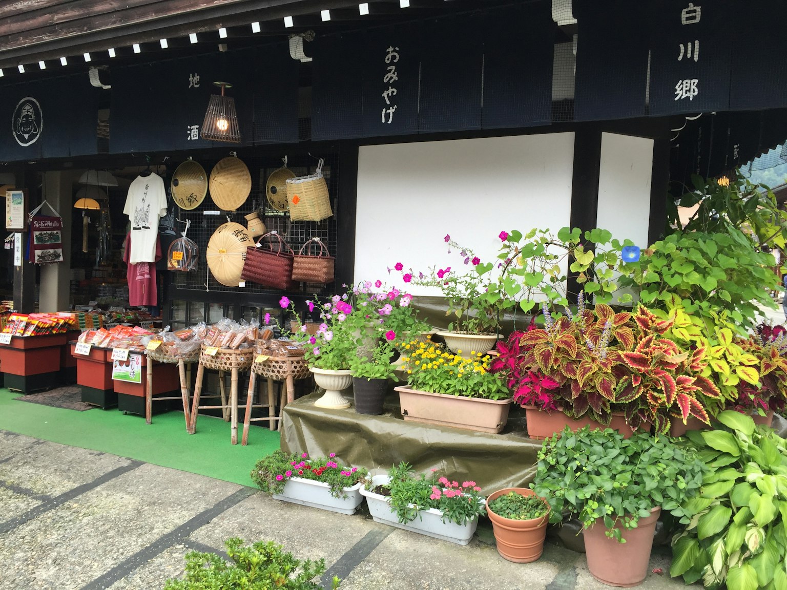 Exterior de una tienda japonesa tradicional con plantas coloridas y productos exhibidos