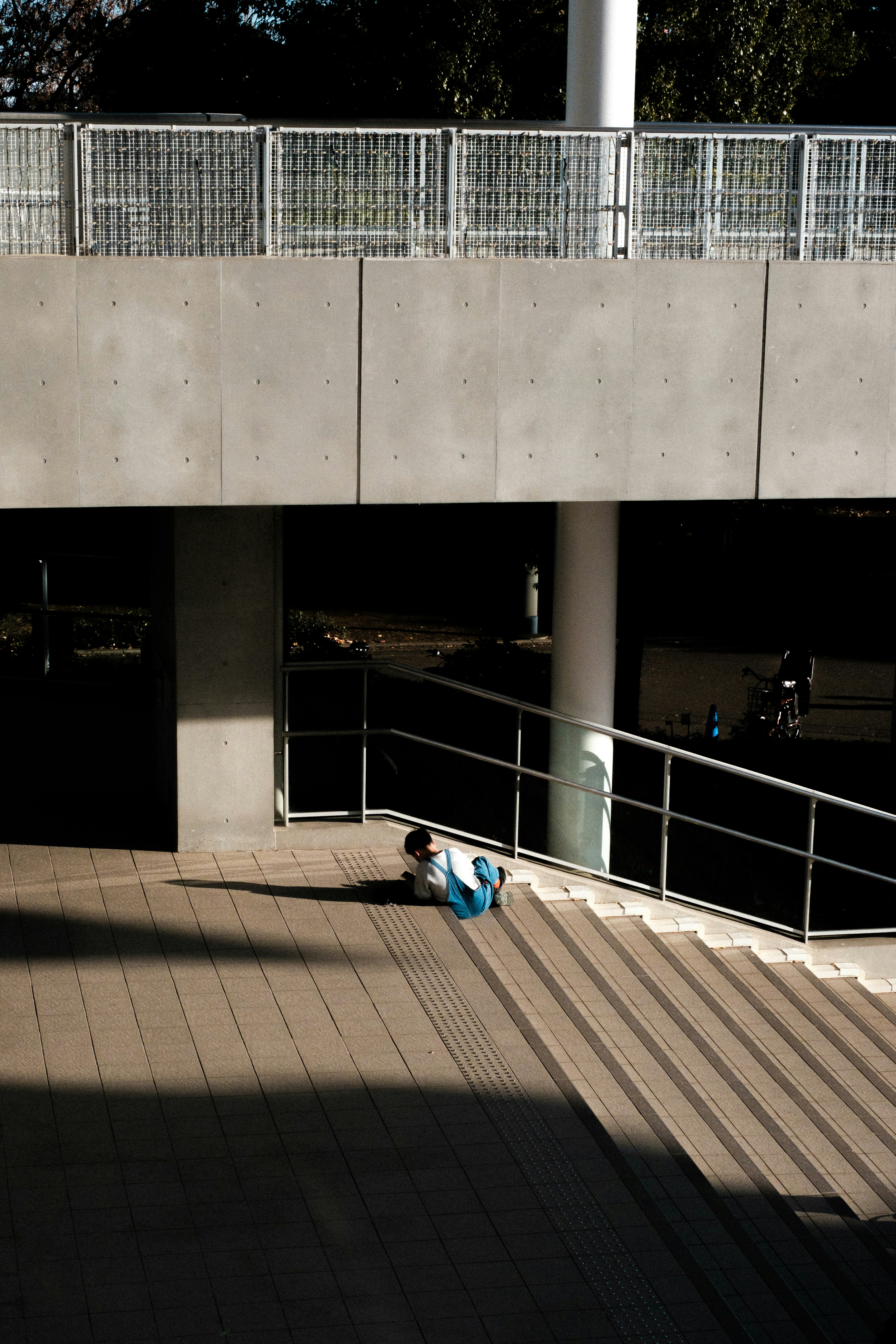 passage sous un mur en béton d’un viaduc, en plein soleil