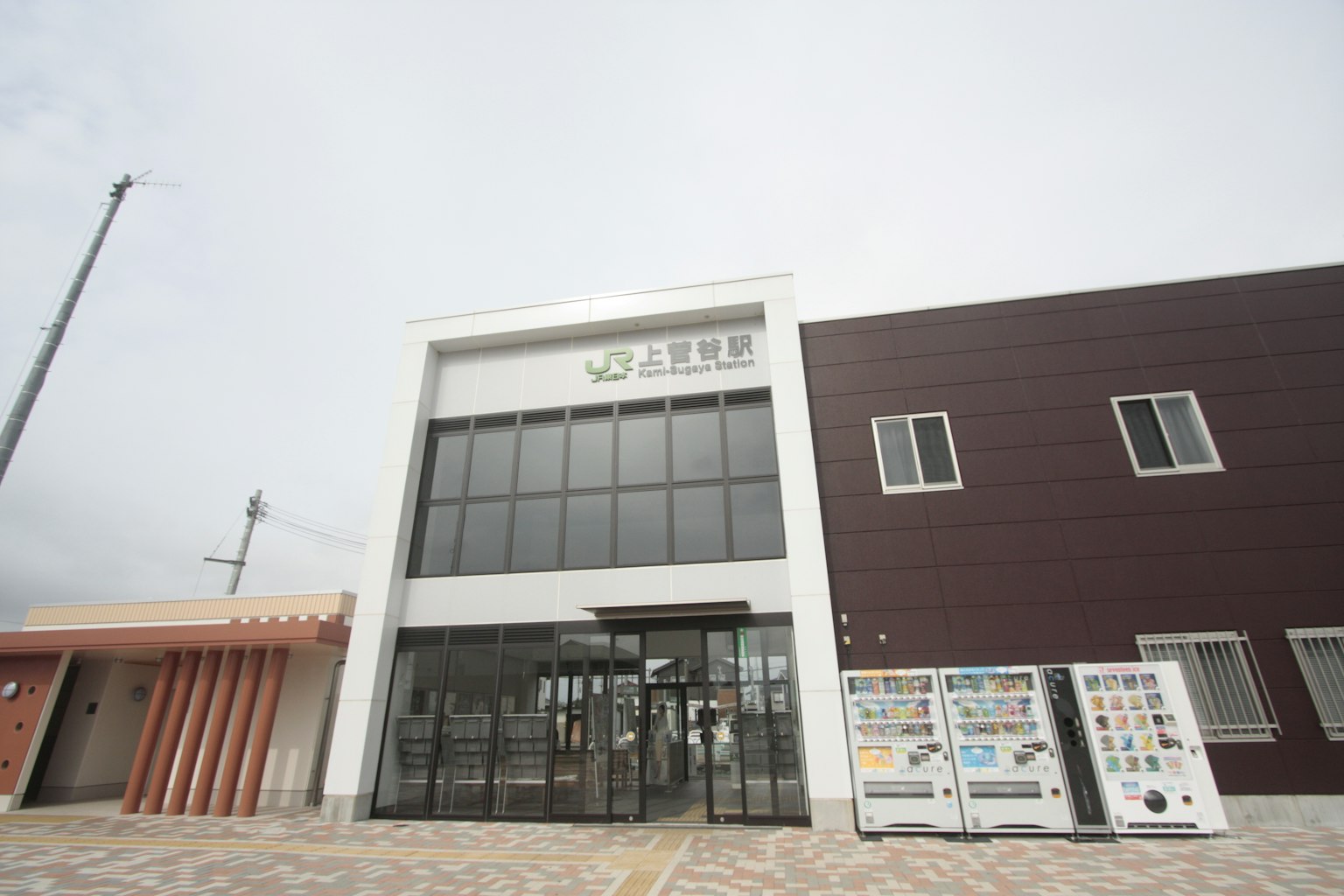Edificio moderno con esterno bianco grande ingresso in vetro parte murale marrone a destra