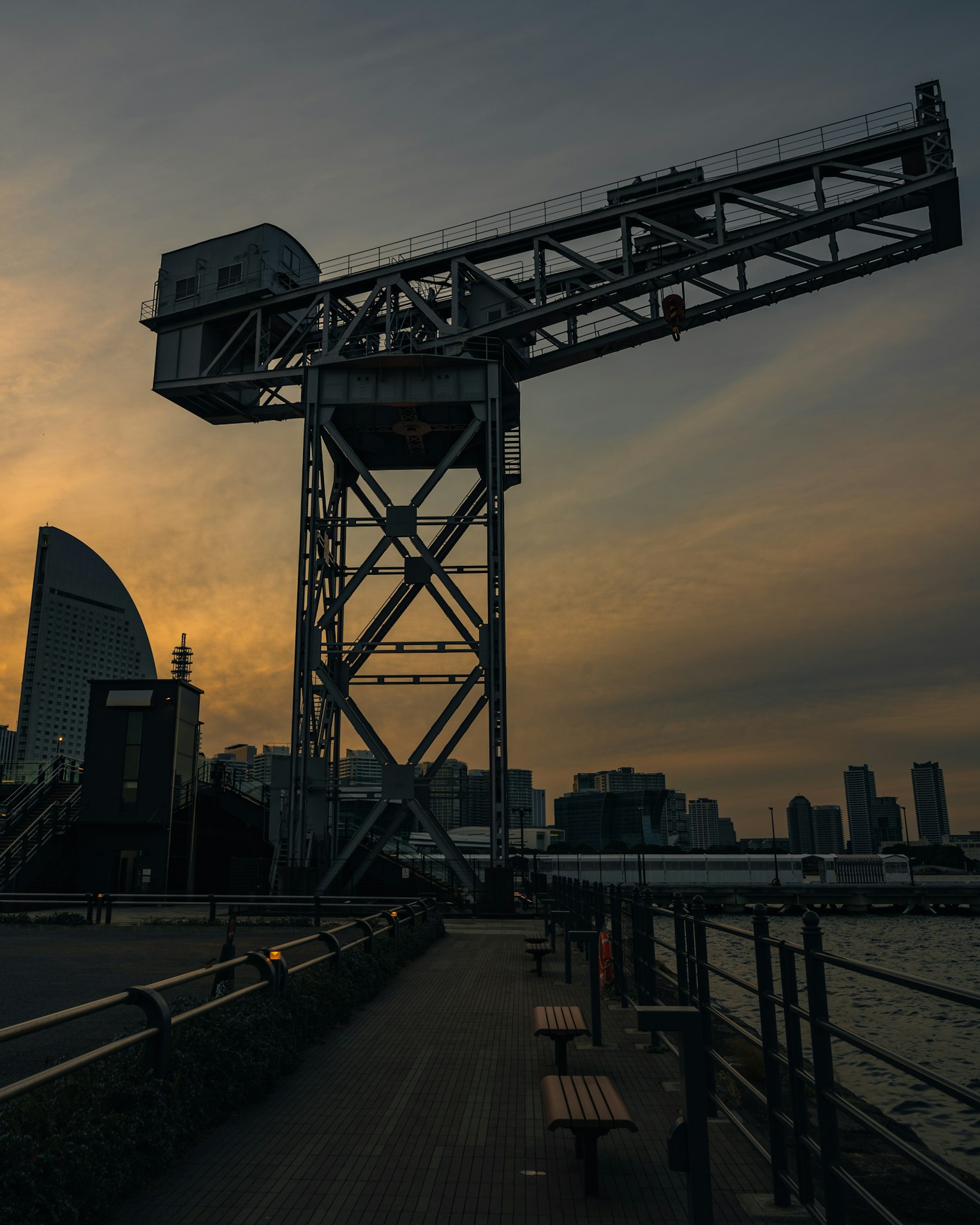 夕阳下的起重机轮廓与城市天际线