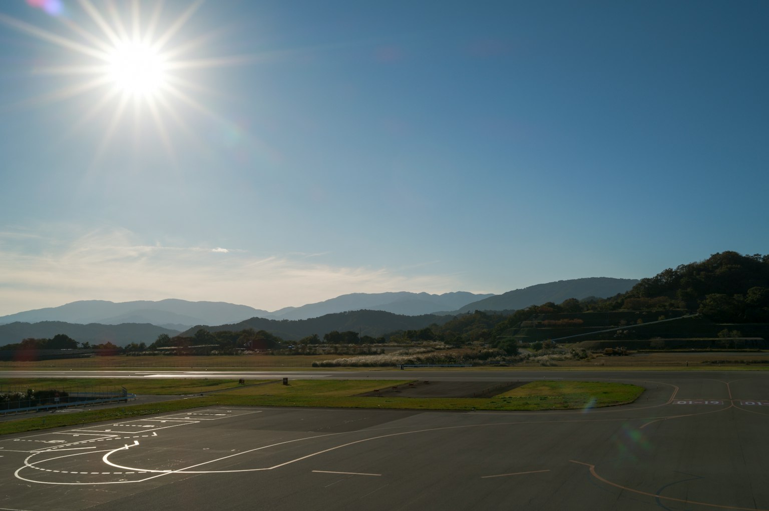 Un paesaggio luminoso con un sole splendente montagne e una pista d'atterraggio