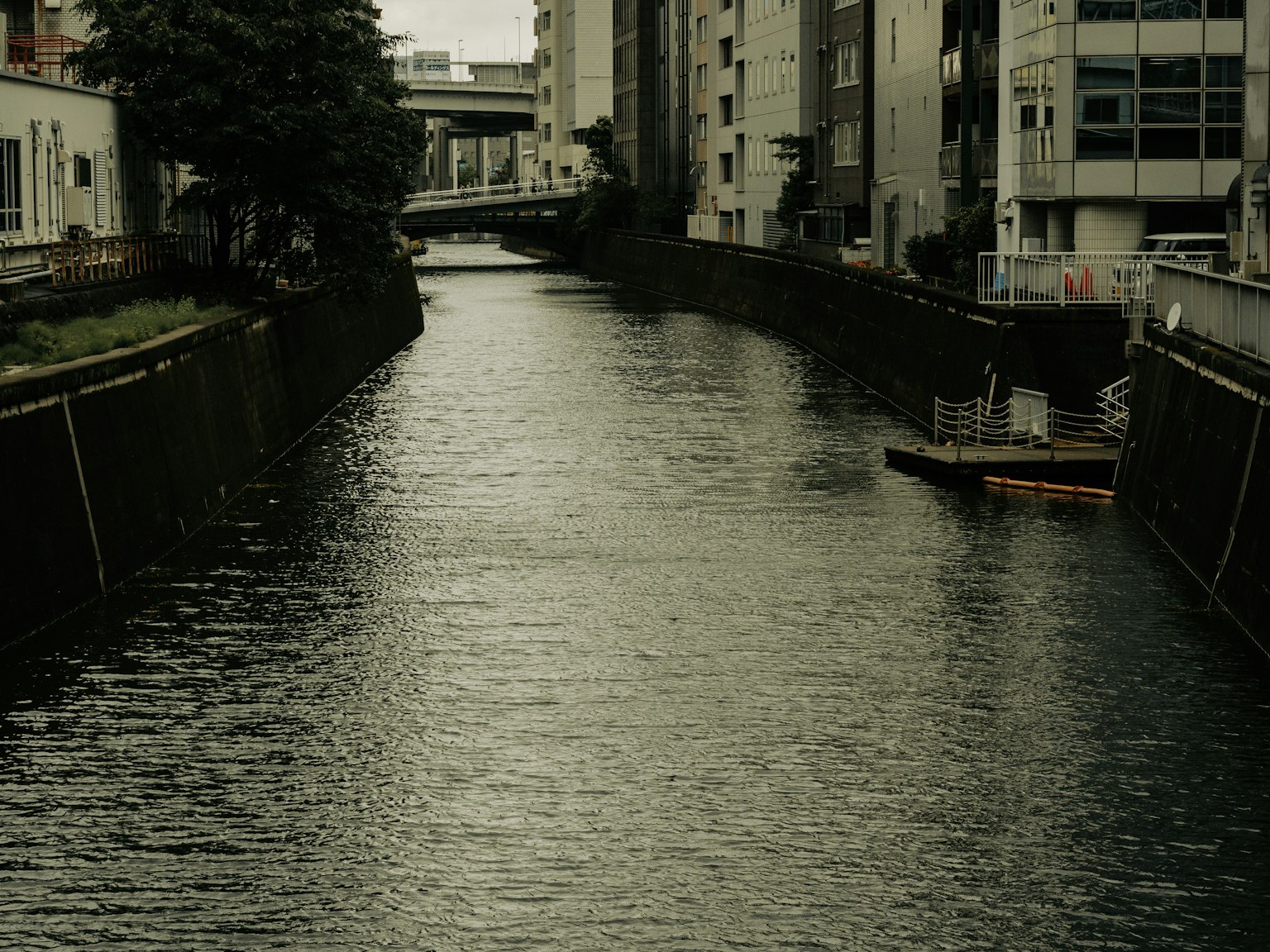 Ruhige städtische Flusslandschaft mit trübem Wasser und umliegenden Gebäuden