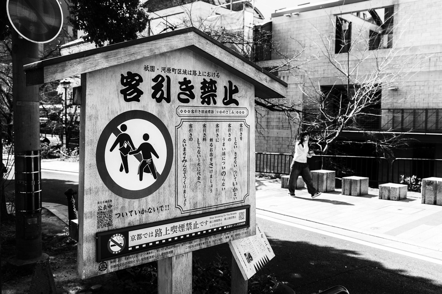 黑白街景，包含禁止招攬的標誌和行人