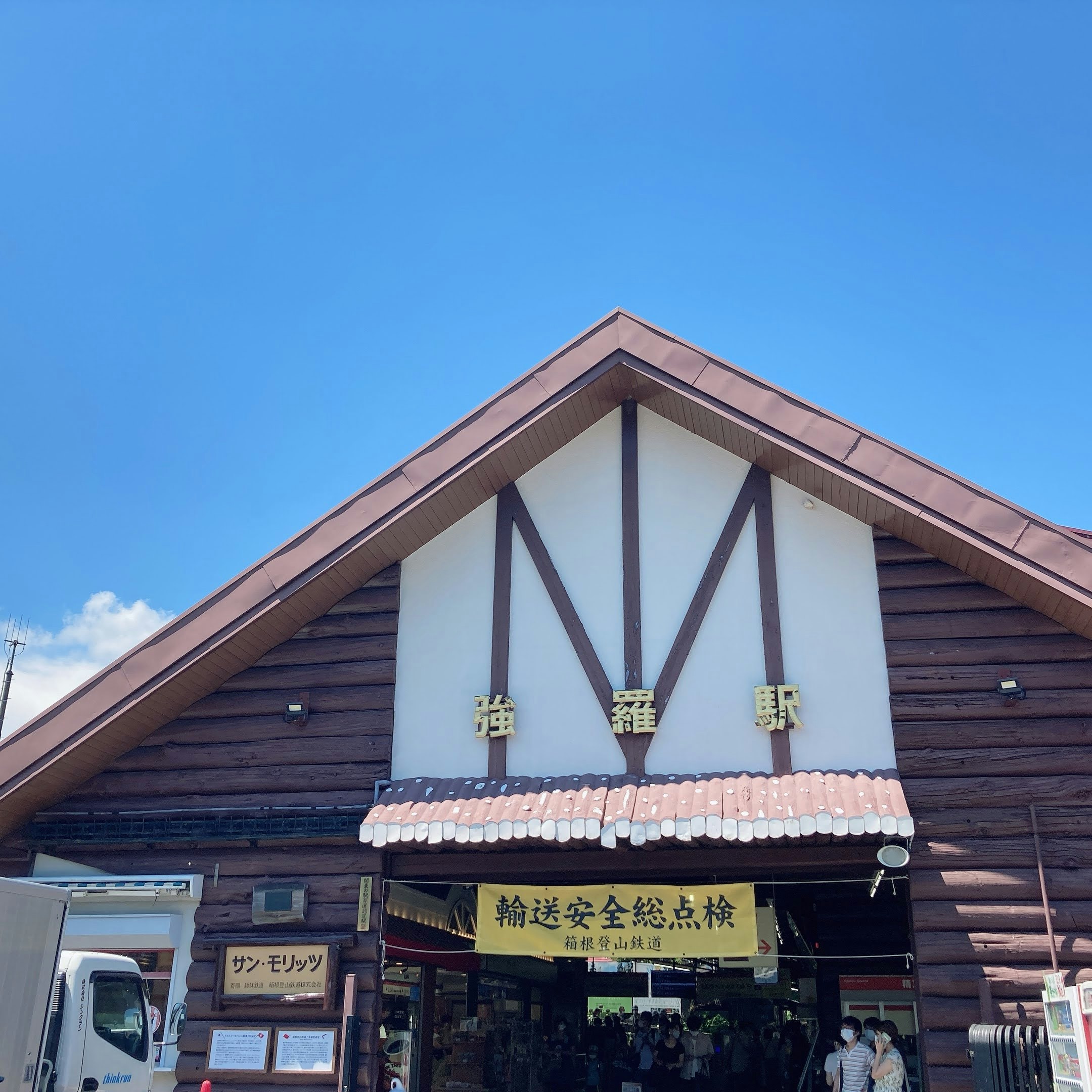 蓝天下的海边车站建筑与店铺招牌