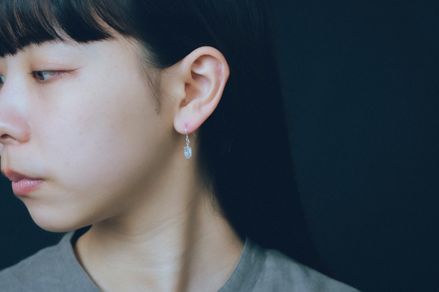 Profil wanita dengan latar belakang sederhana dan anting berkilau