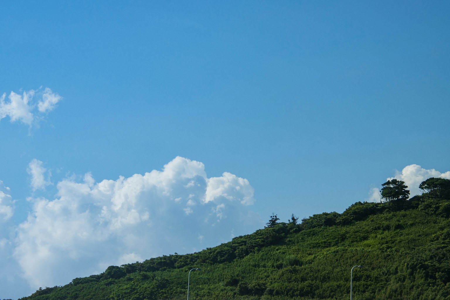 Pemandangan dengan langit biru dan bukit hijau