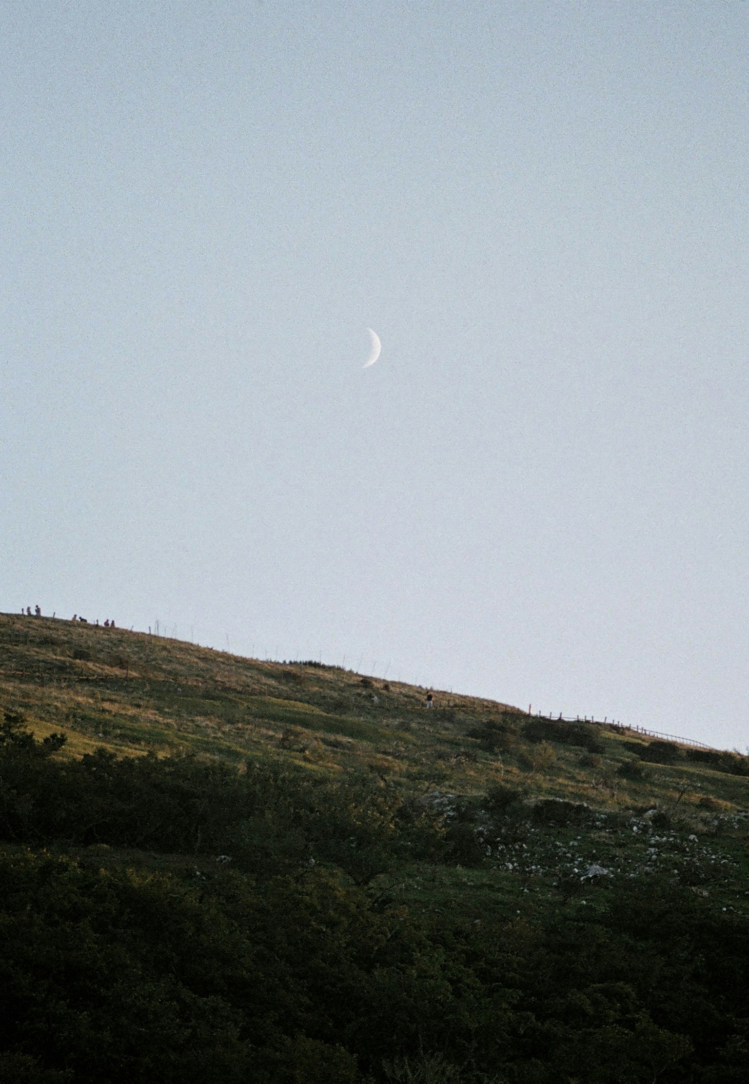山の上に浮かぶ月と青空の風景