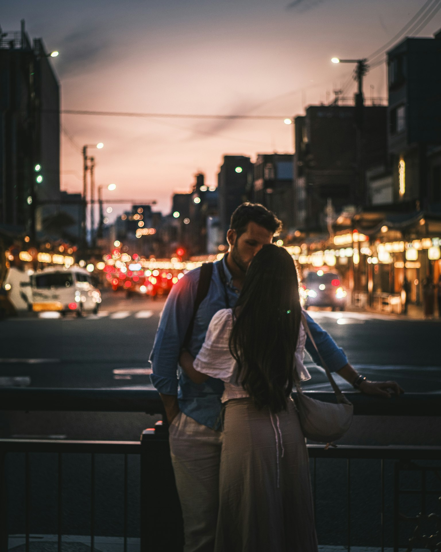 Silhouette of a couple kissing in a city at dusk