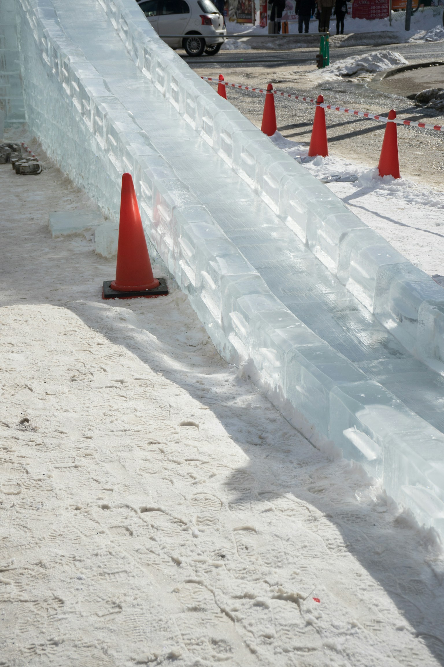 Tobogán de hielo con conos naranjas en un entorno invernal