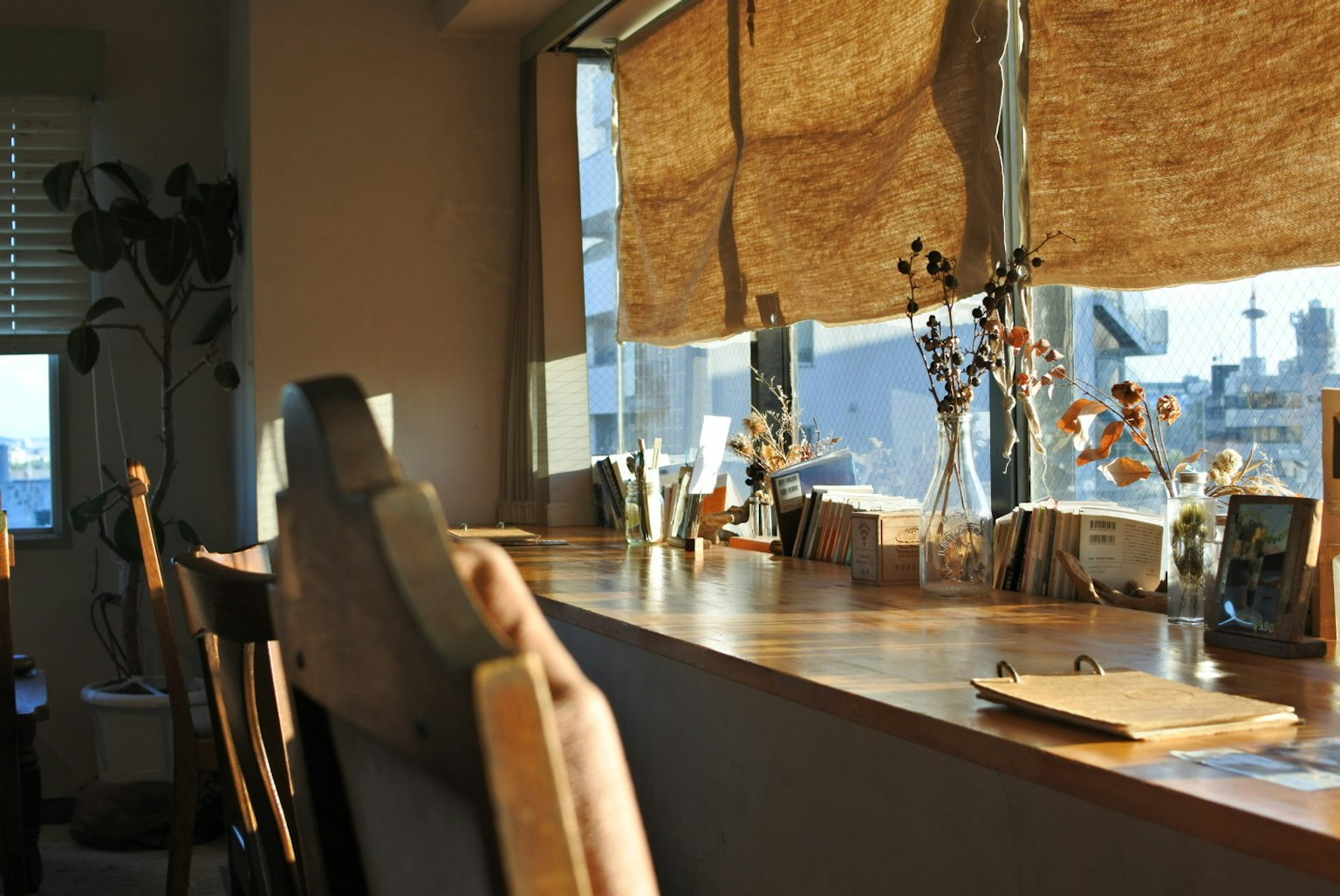 Bright window-side counter with chairs and small vases on the table