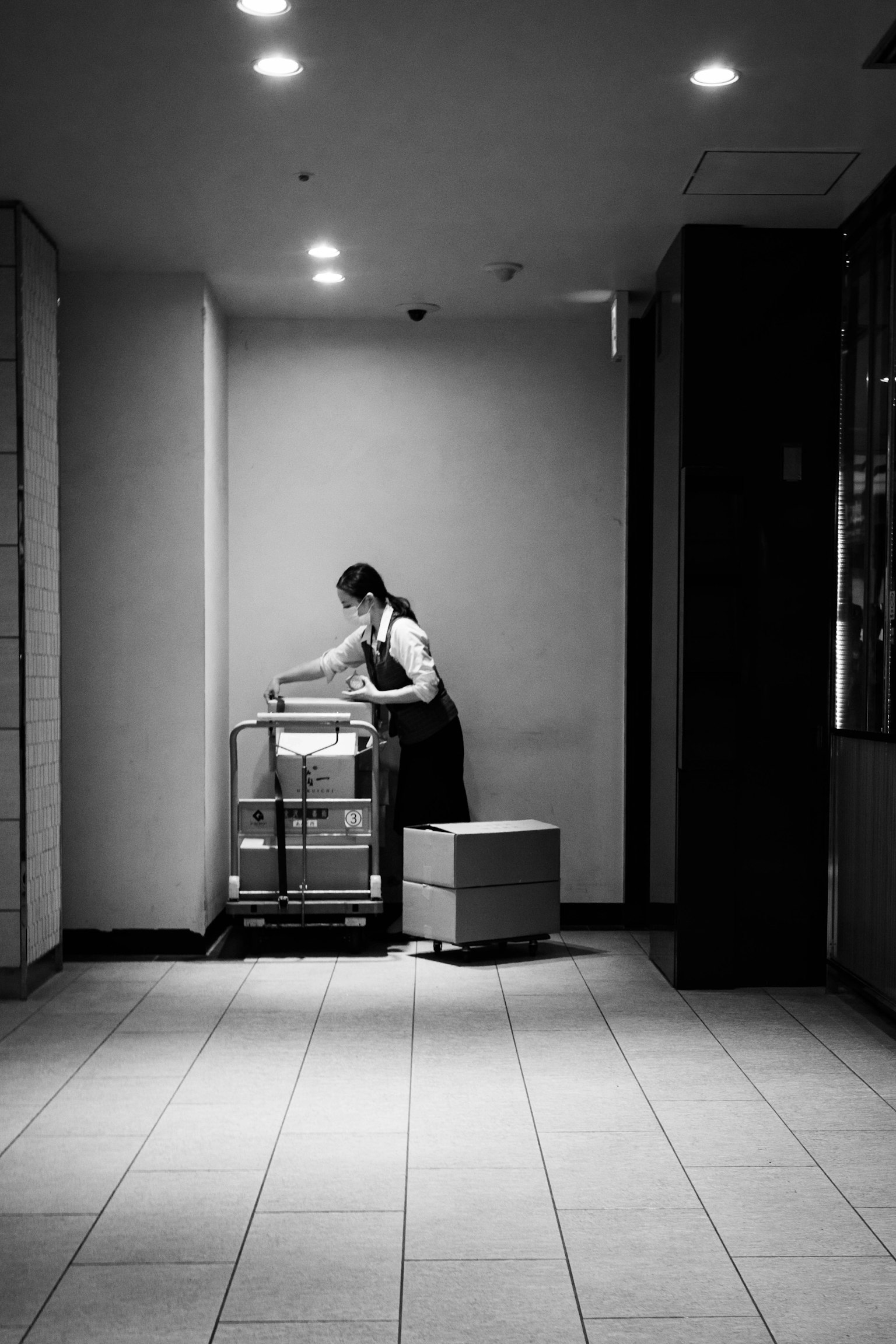 Eine Frau arbeitet mit einem Wagen in einem schwarz-weißen Raum