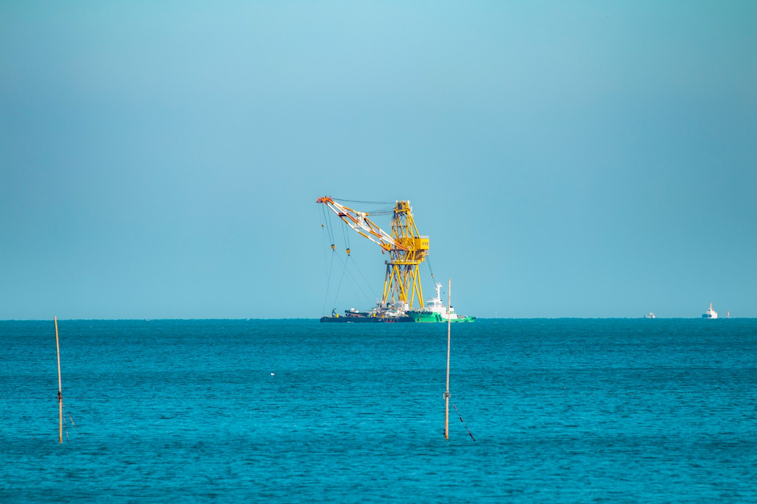 海上漂浮的黄色起重机和船只的图像