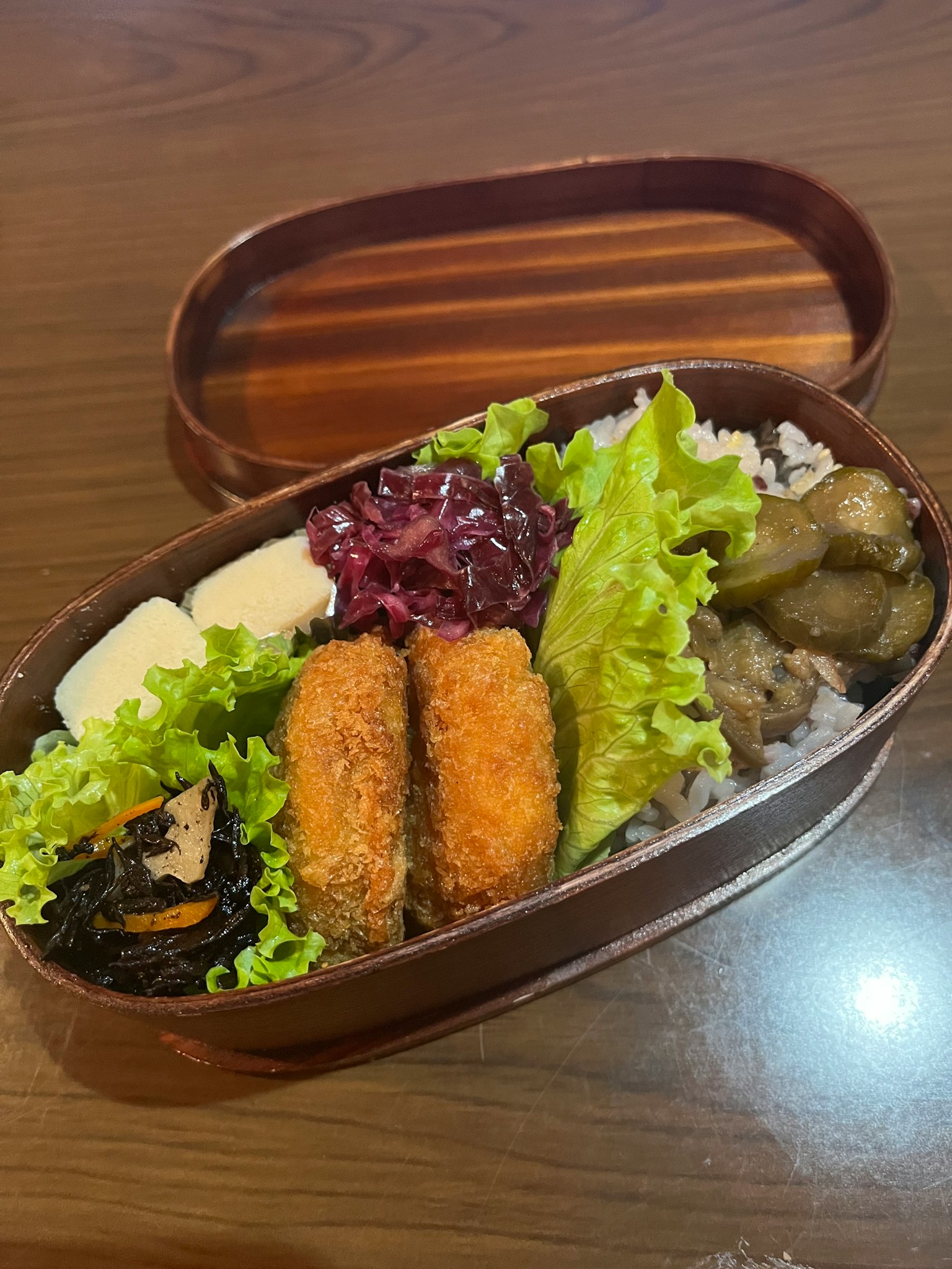 一個裝滿米飯和各種蔬菜菜餚的便當盒