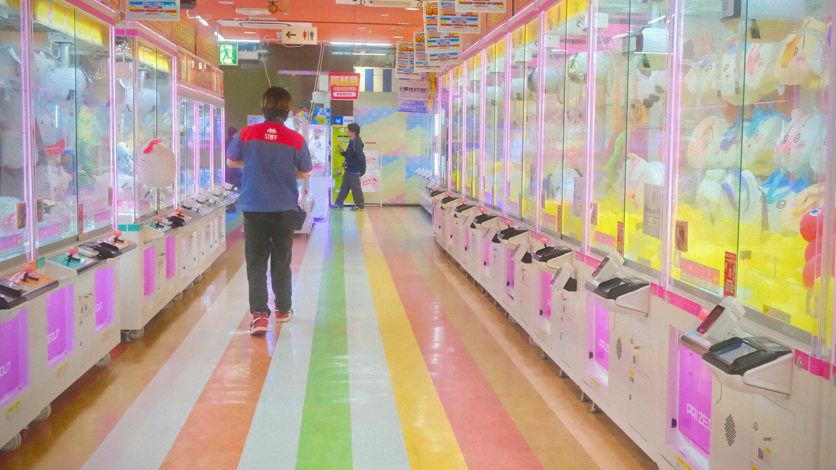 カラフルな景品が並ぶ屋内のゲームコーナー通路