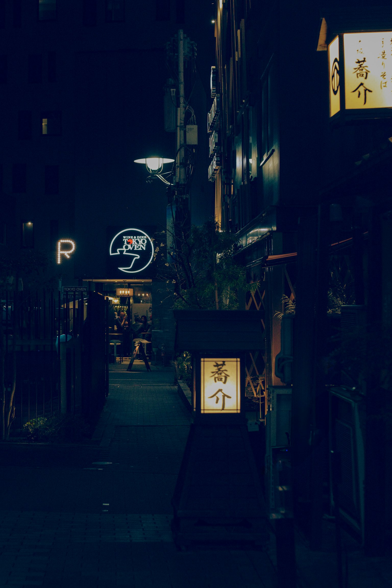 Scena di strada di notte con insegne di ristoranti illuminate e luci al neon