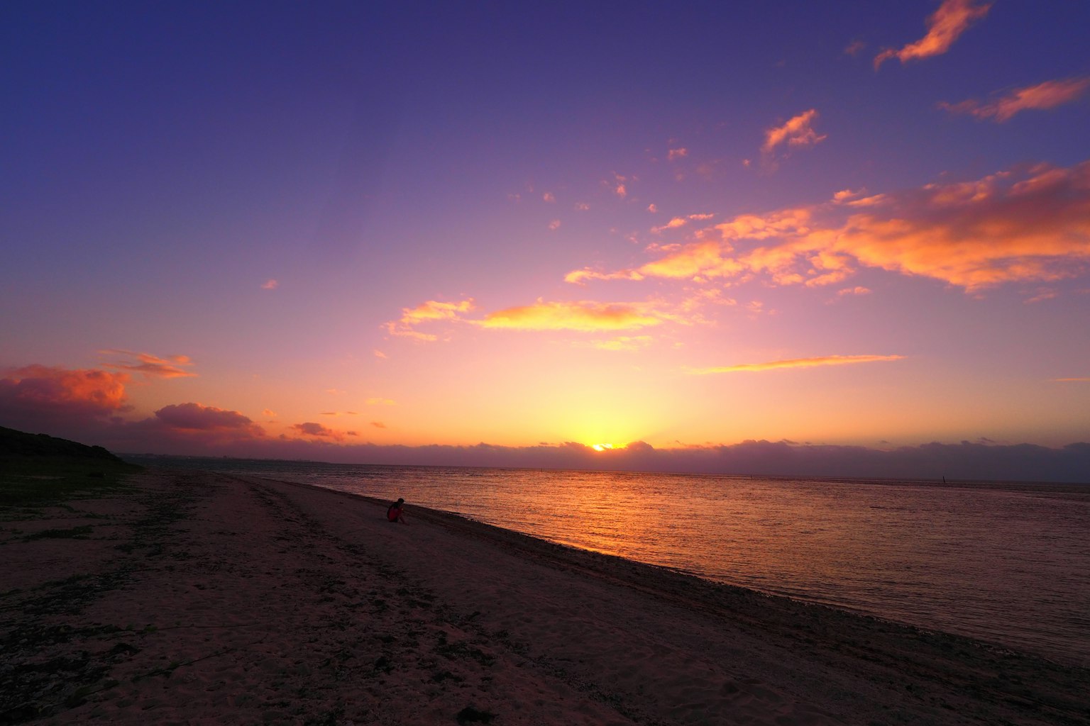 Sunset beach landscape with orange and purple sky calm water surface