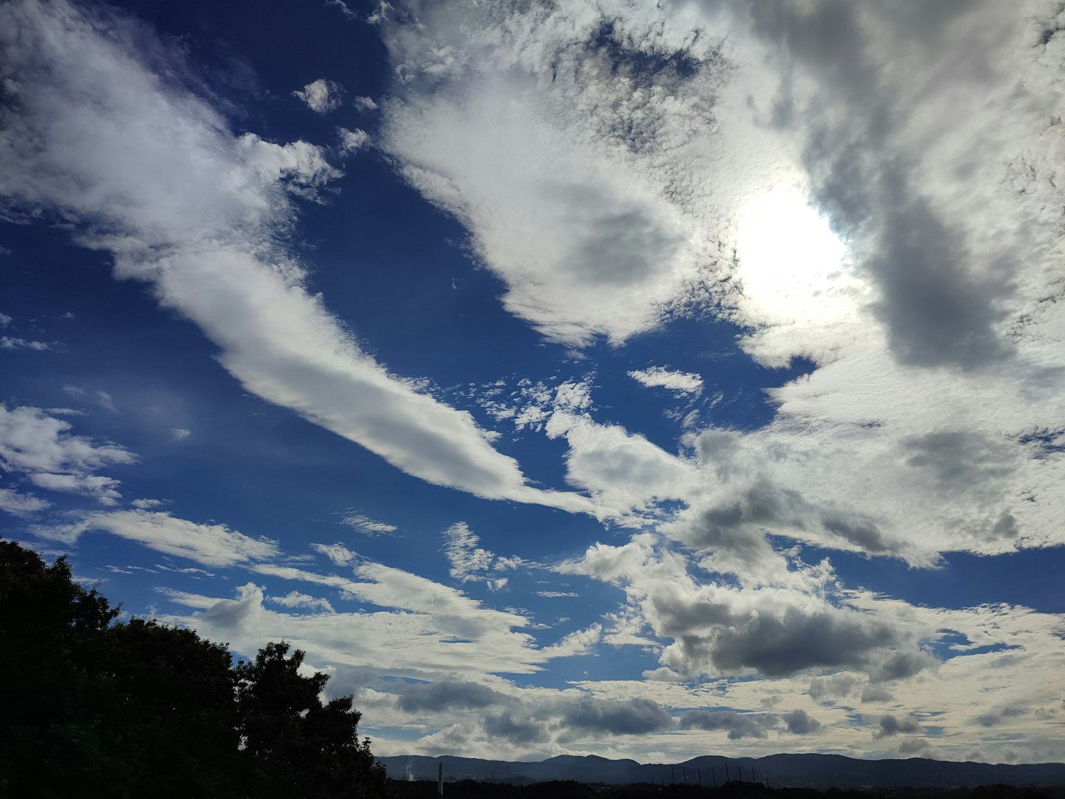Eine malerische Aussicht auf den blauen Himmel mit weißen Wolken Sonnenlicht strahlt durch