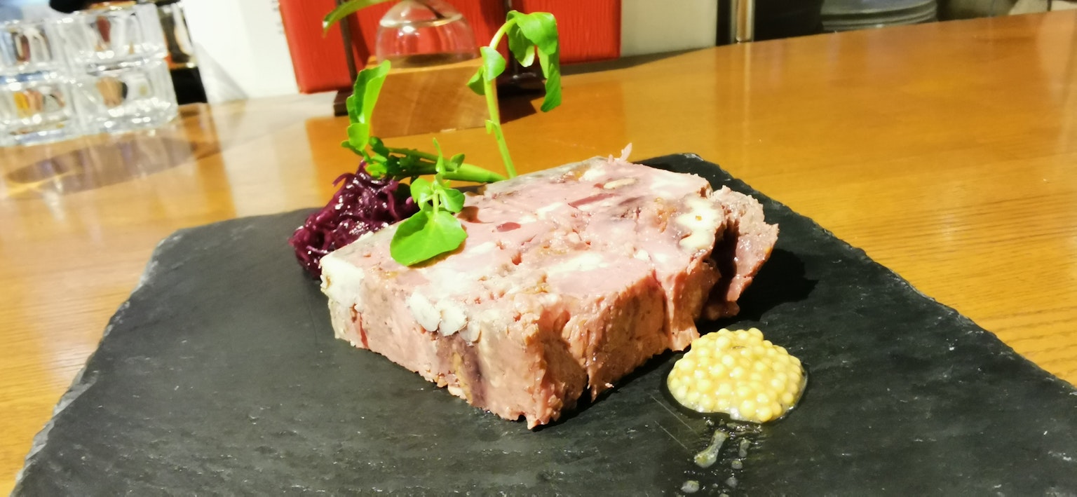 一盤精美擺盤的肉菜餚在石板上