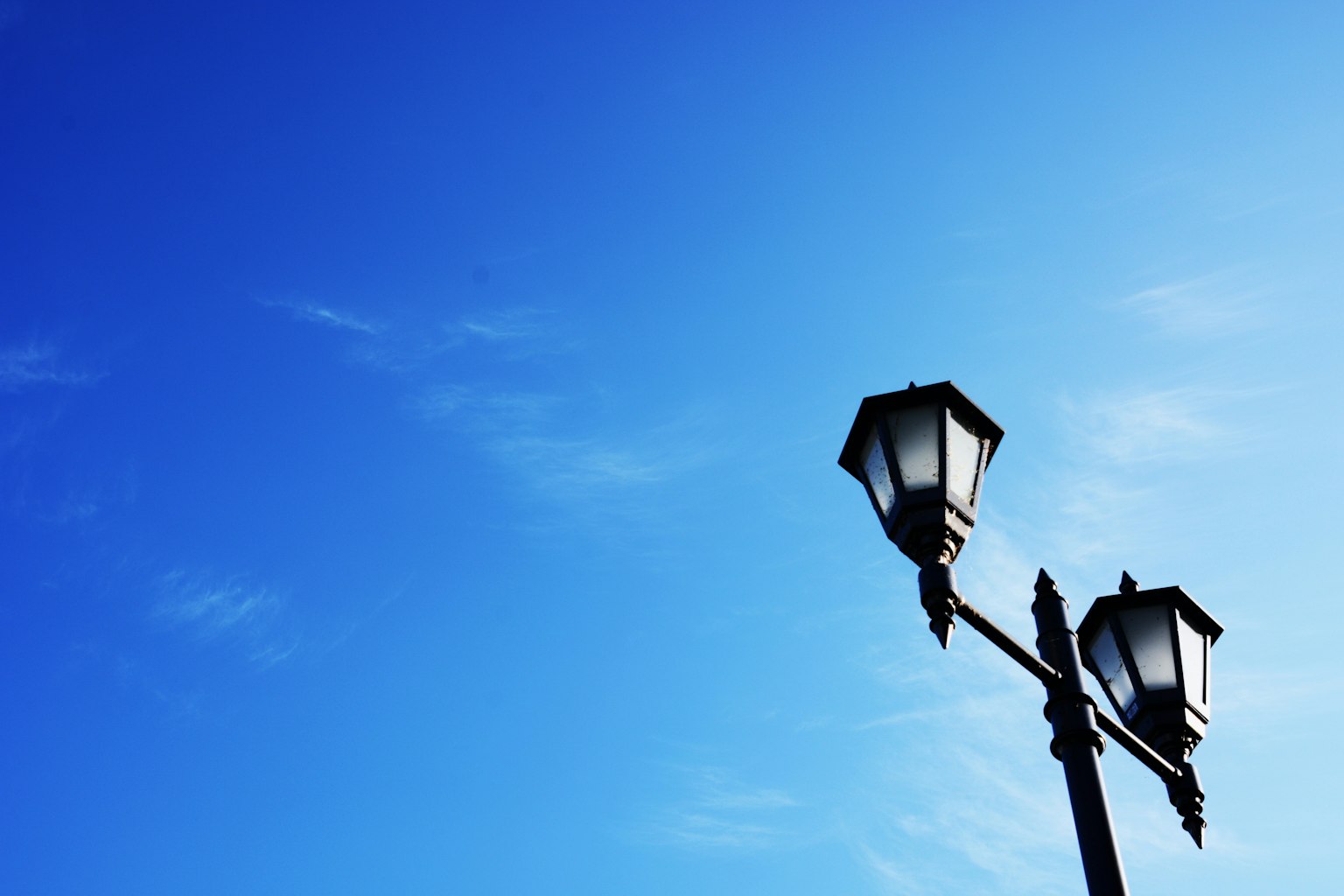 Silhouette de lampadaires contre un ciel bleu
