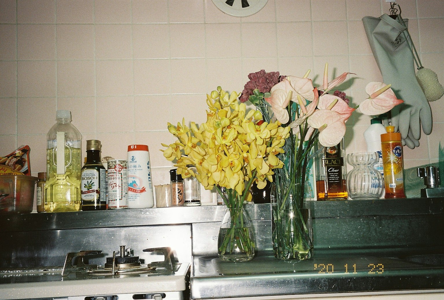 Vasi con fiori gialli e rosa su un piano cucina