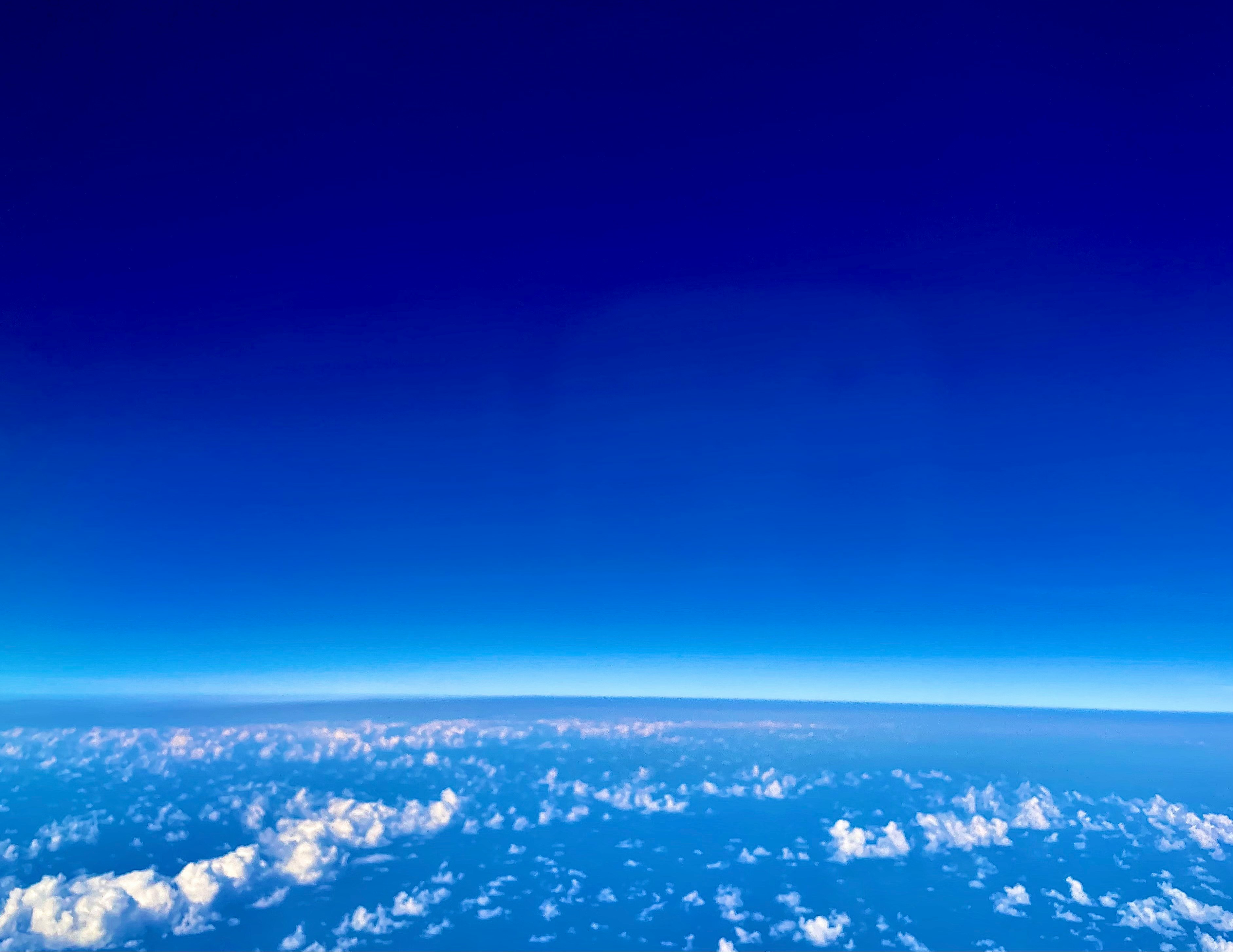 青い空と雲海の上に広がる地球の眺め