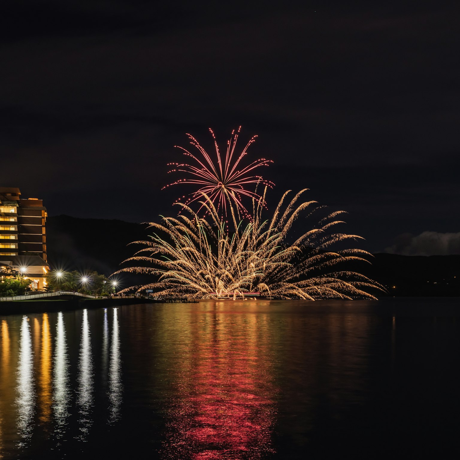 Magnifique feu d'artifice dans le ciel nocturne avec des reflets sur l'eau