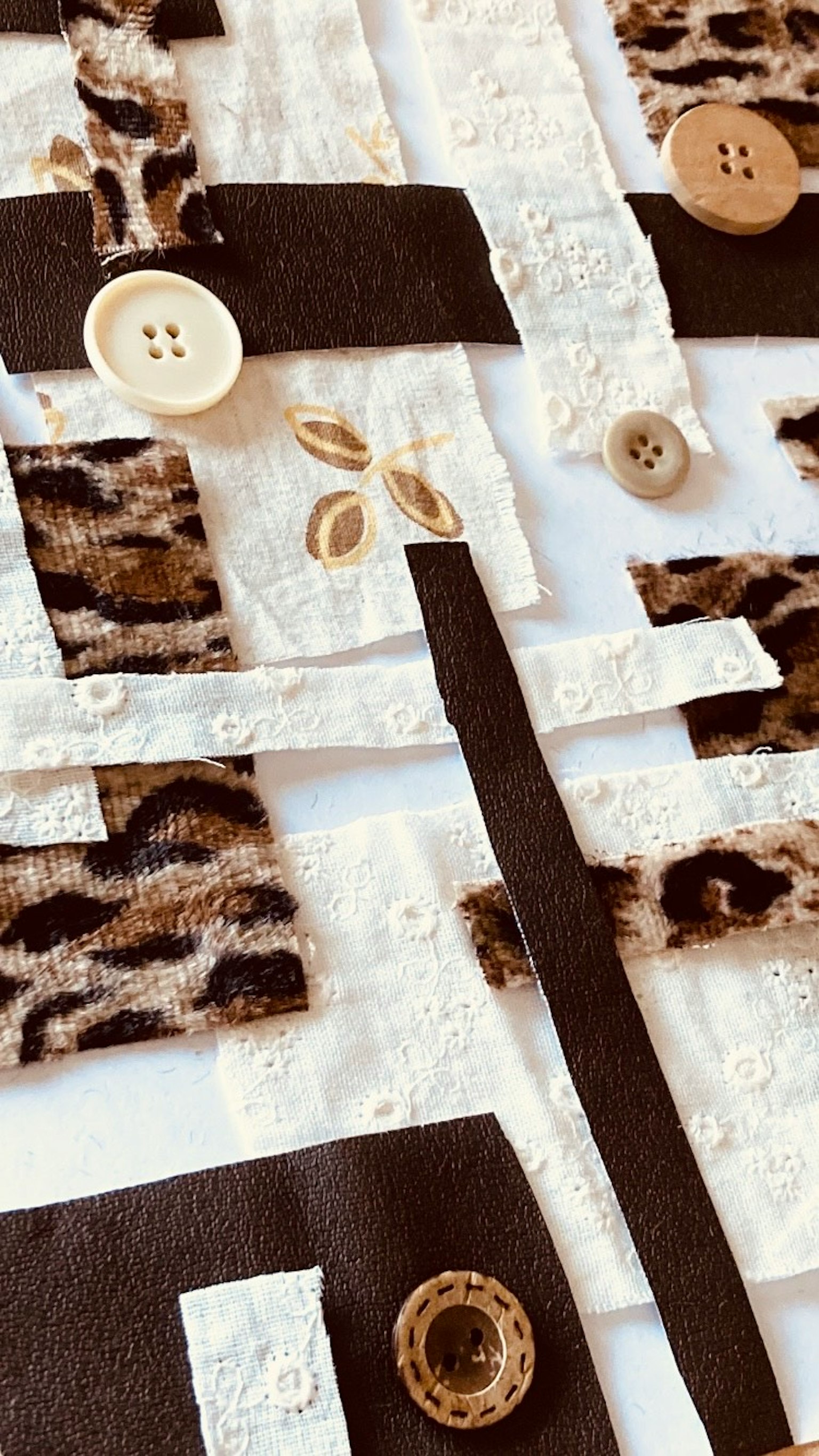 Collage unico di pezzi di tessuto e bottoni disposti in un motivo