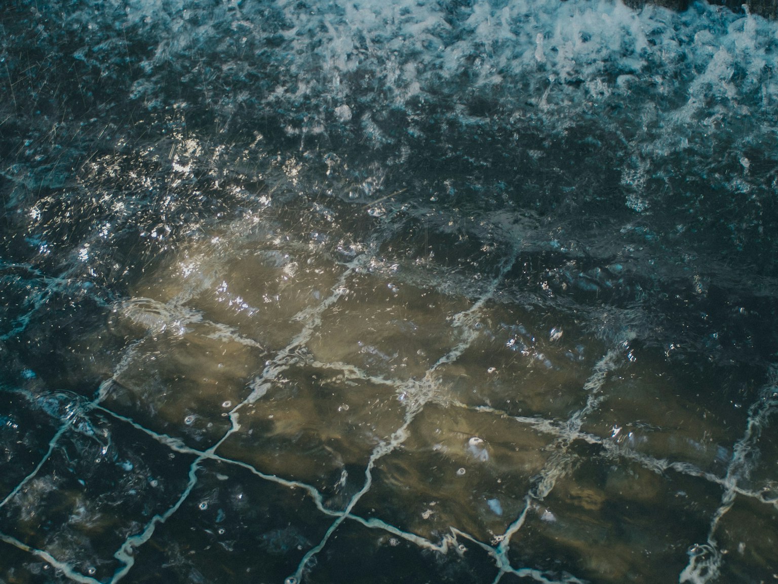 Immagine che mostra riflessi di luce sull'acqua e motivi di piastrelle