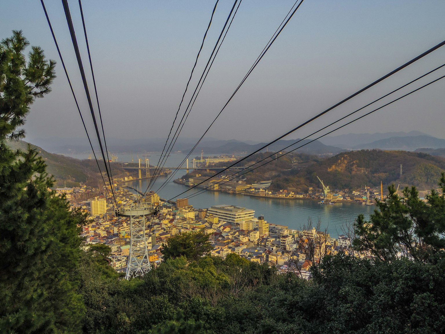 Vista panoramica di una città e di un fiume da una montagna con linee della funivia