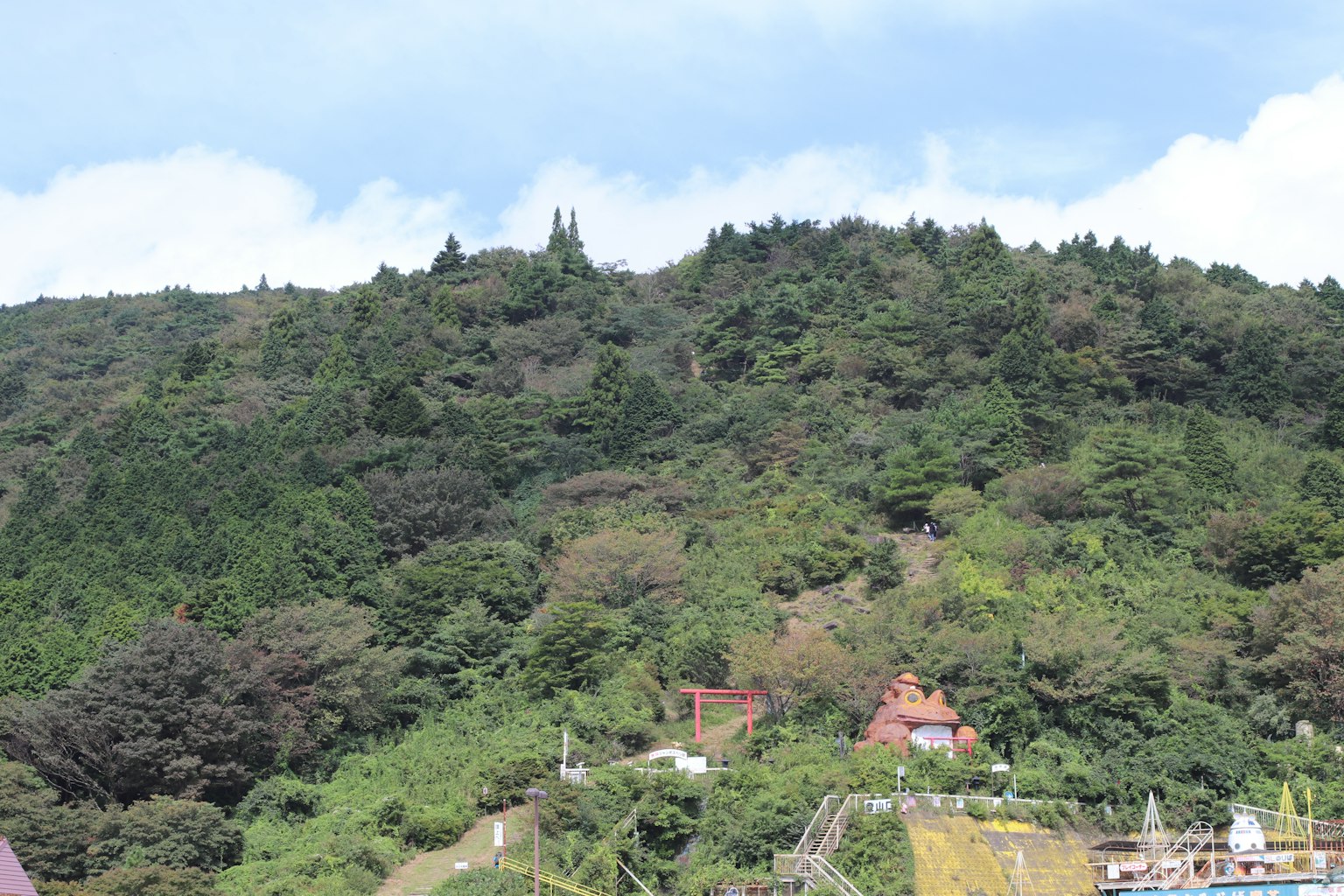 Pemandangan gunung hijau subur dengan rumah-rumah yang tersebar
