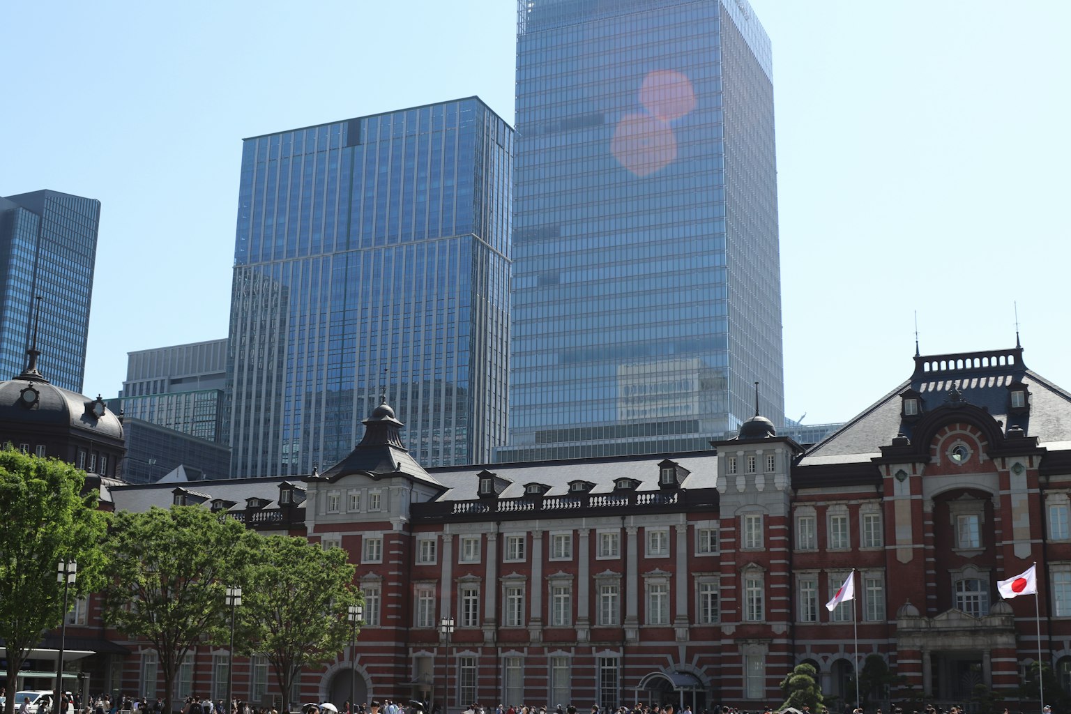 Kontras antara Stasiun Tokyo dan gedung pencakar langit di bawah langit cerah