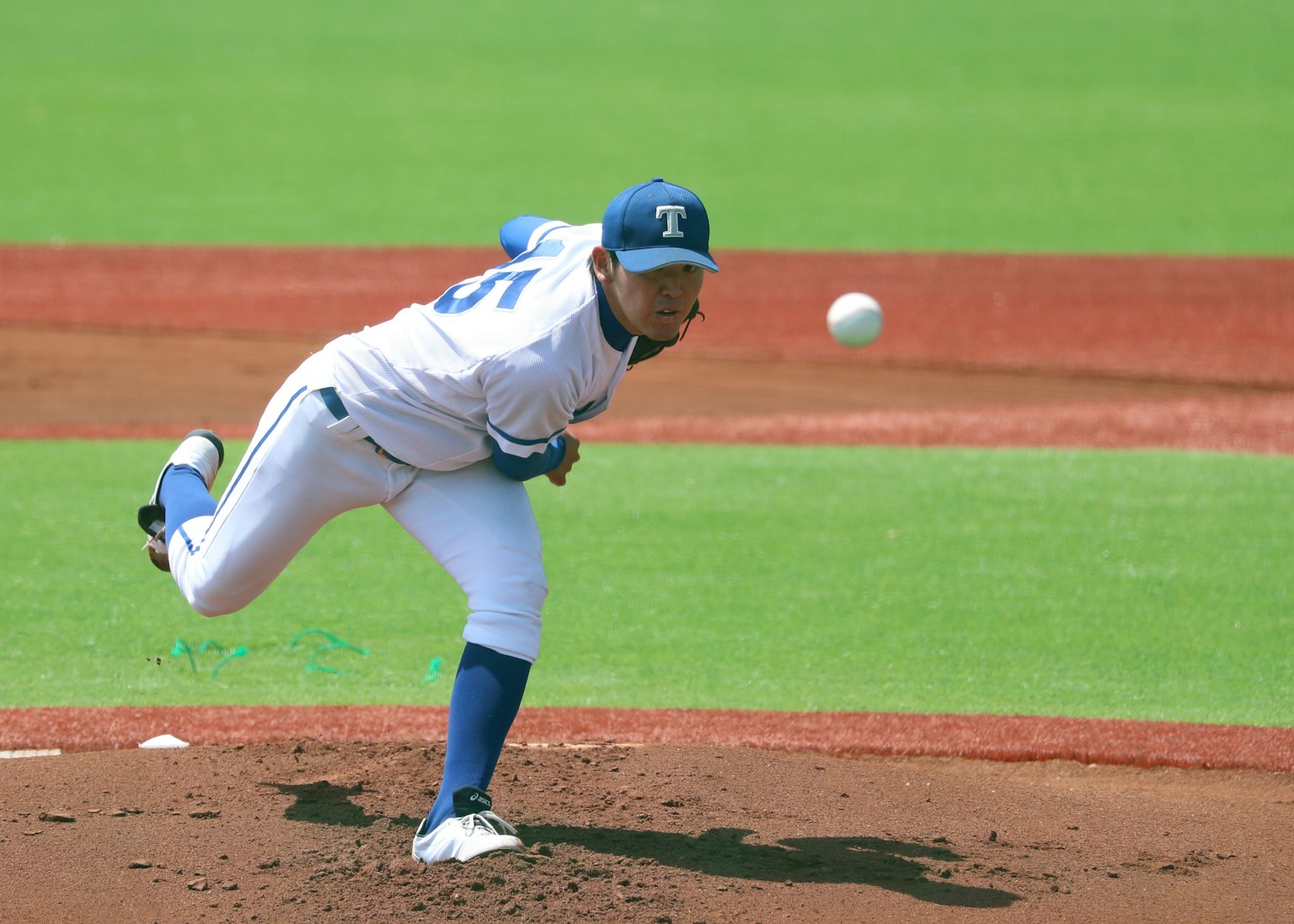 Un lanciatore di baseball che lancia una palla sul monte