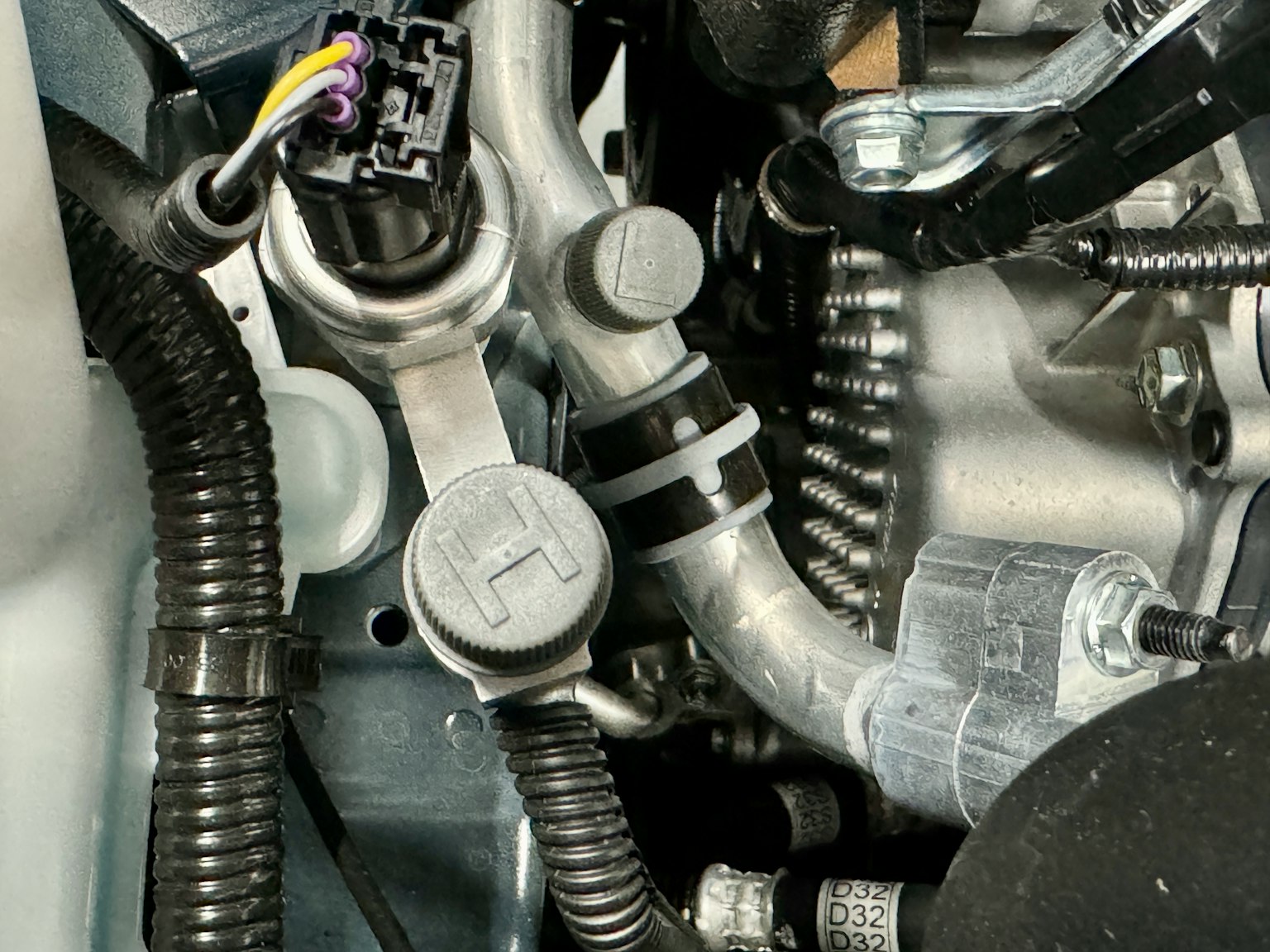 Vista detallada de los componentes del compartimento del motor incluyendo tubos y conectores