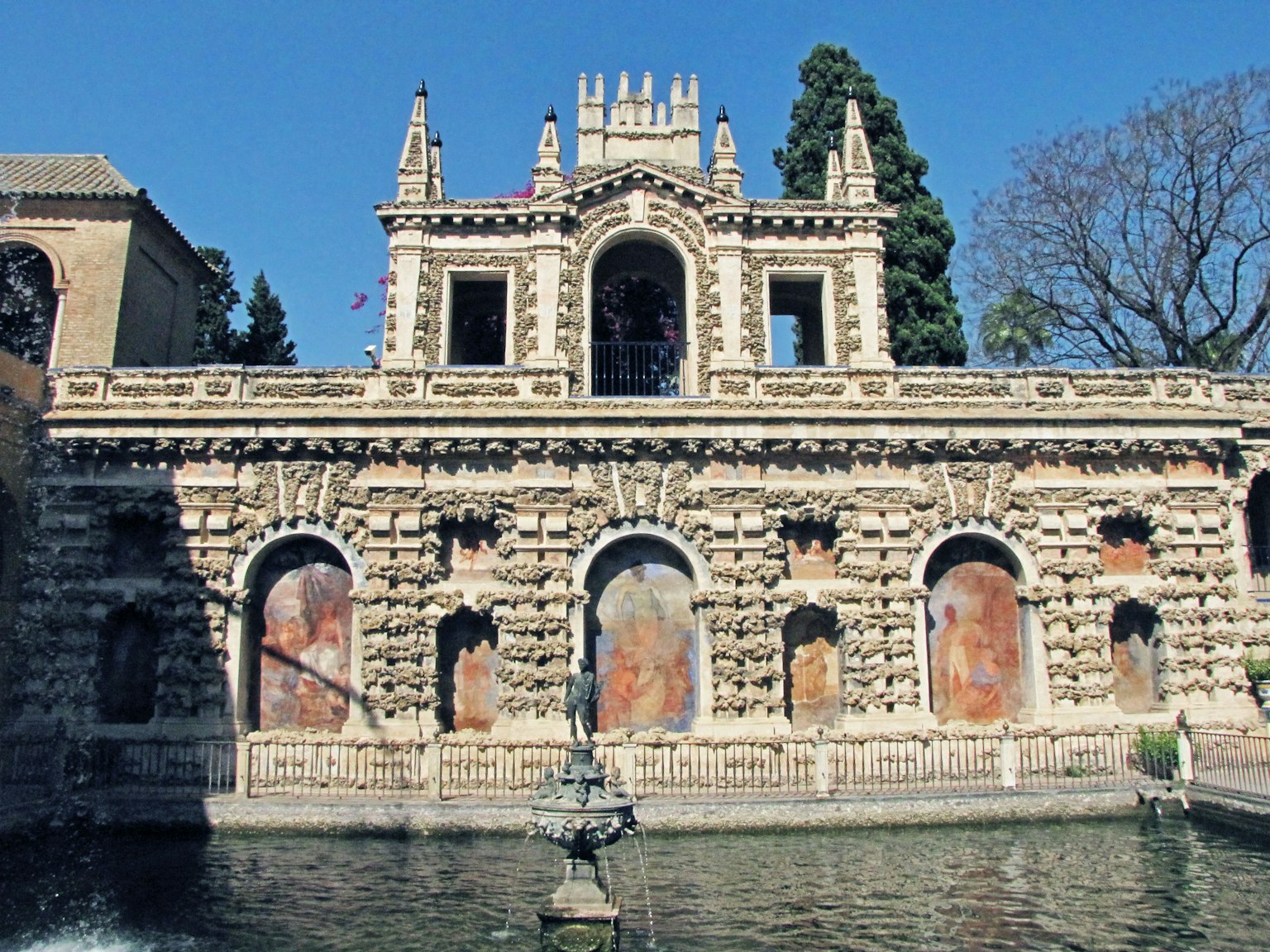 Bâtiment historique avec fontaine et étang présentant une architecture complexe