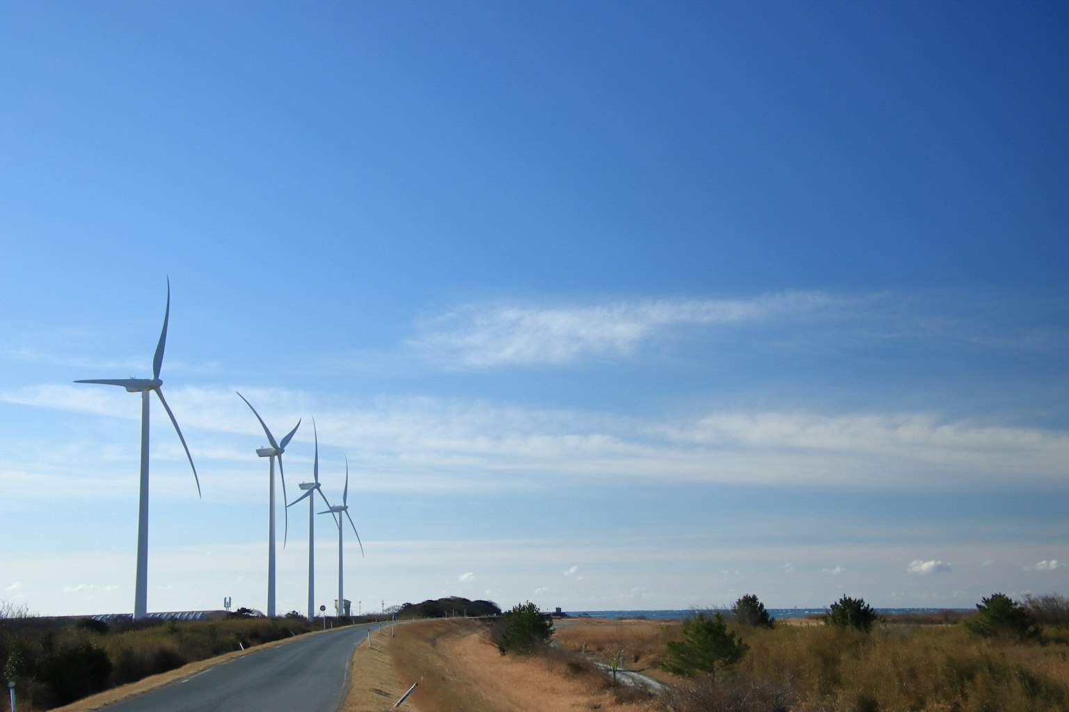 沿著道路的風力發電機景觀晴朗的藍天與草地