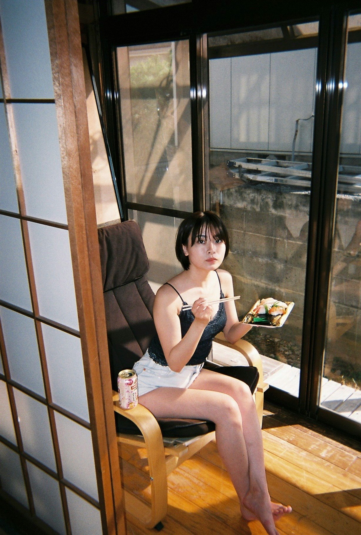 大きな窓のある室内で椅子に座る女性