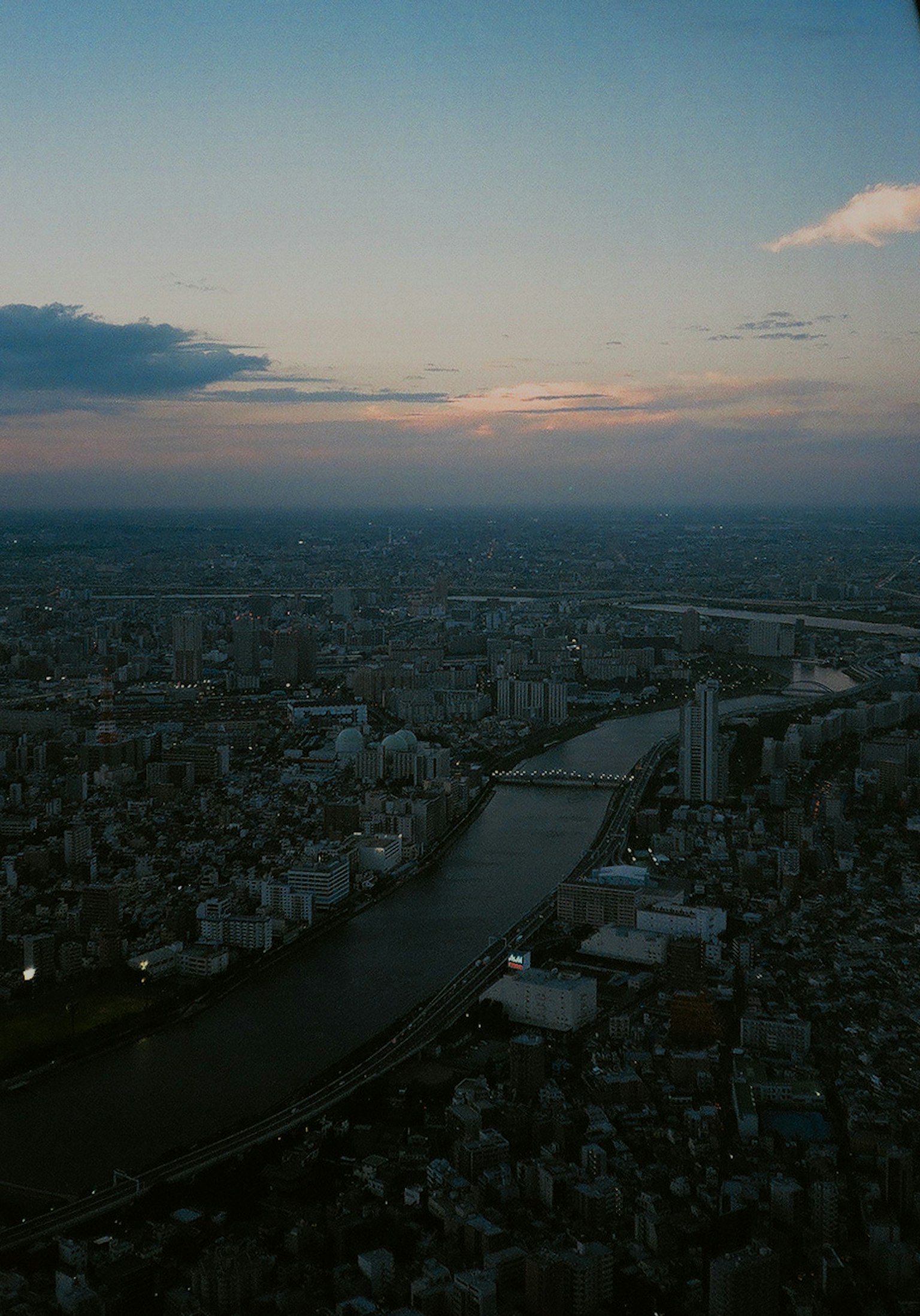 Vista aerea di una città al crepuscolo con un fiume sinuoso